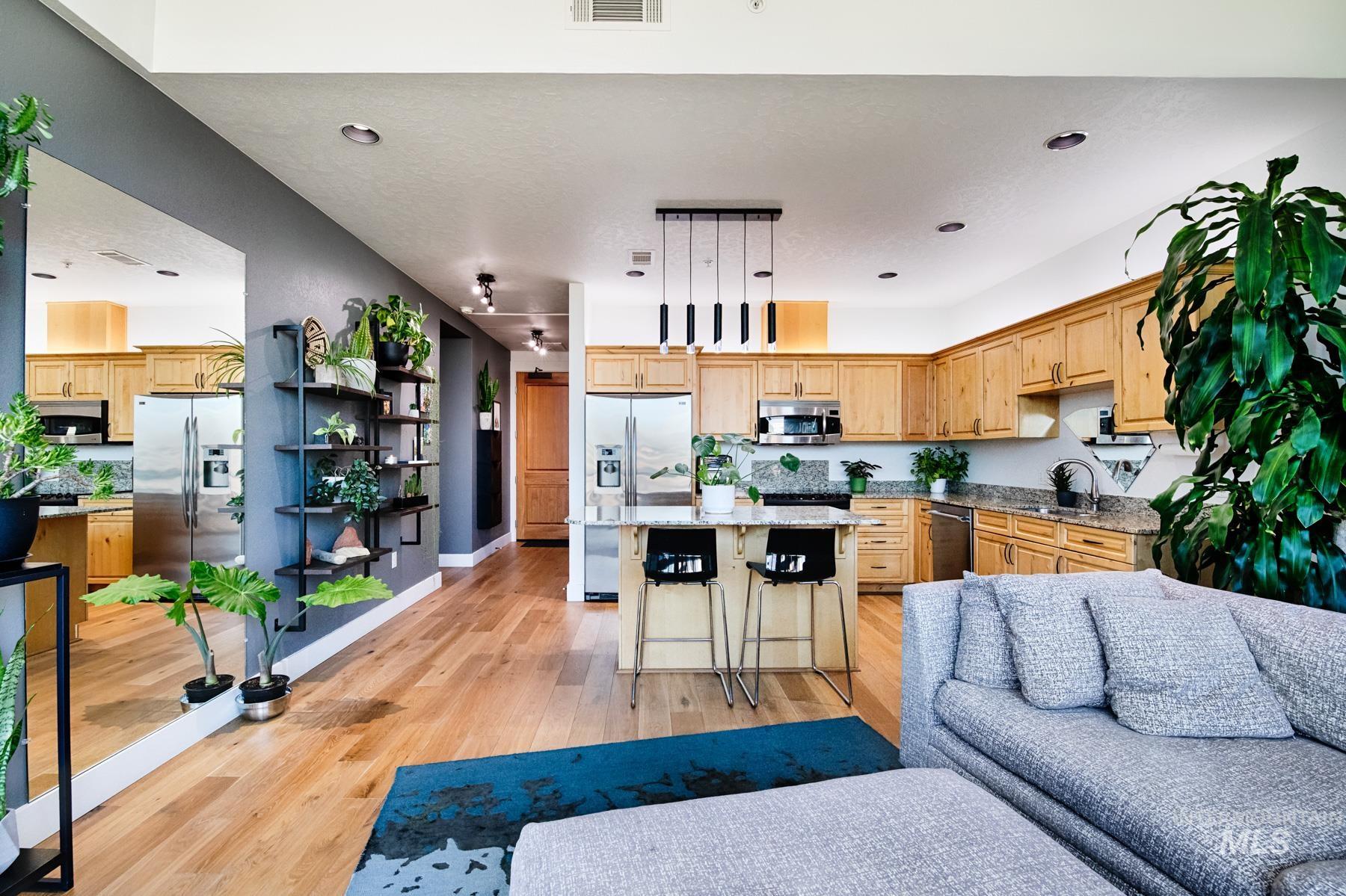 Kitchen with a kitchen island, a breakfast bar area, appliances with stainless steel finishes, light stone counters, and open floor plan