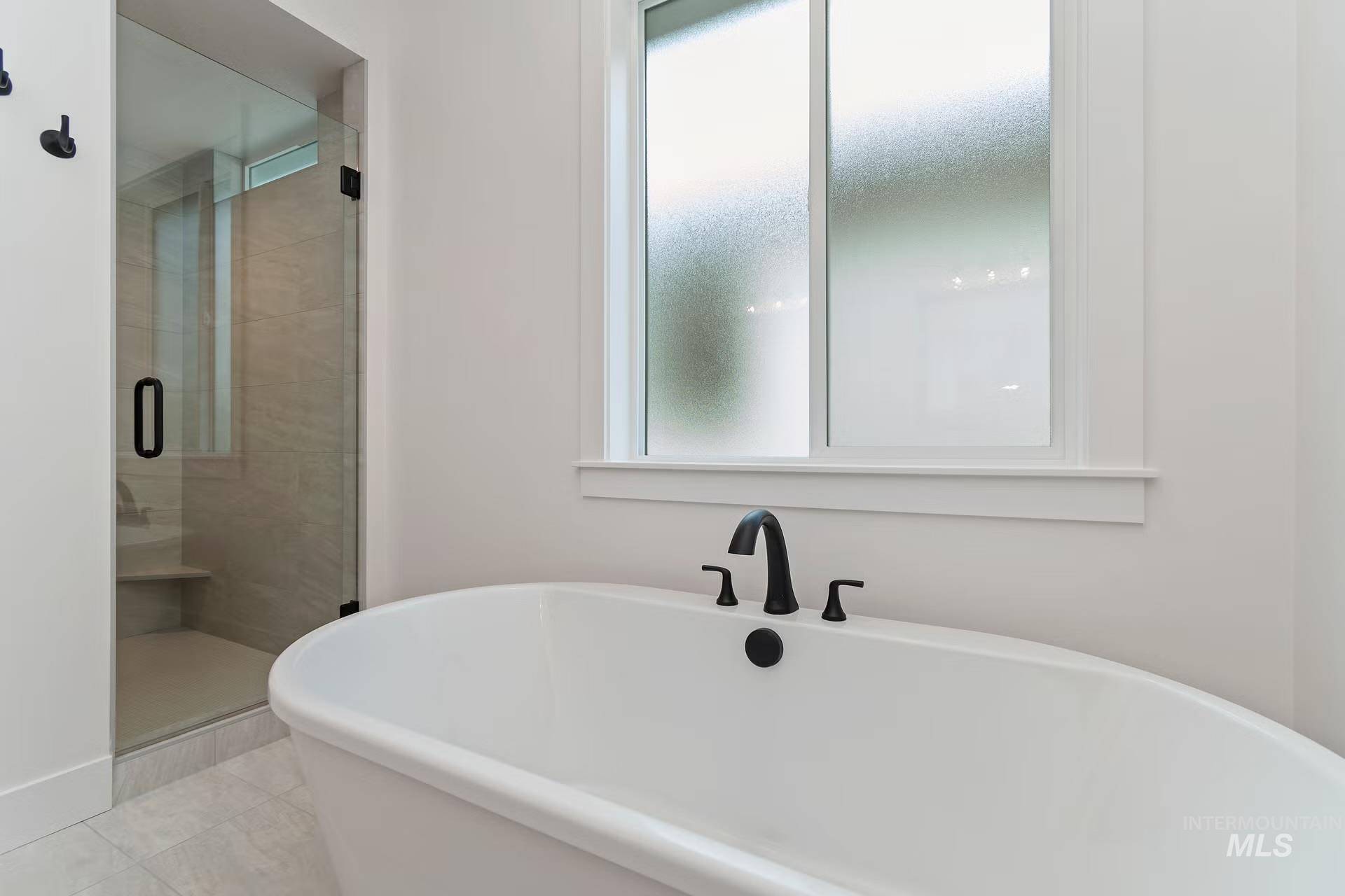 Bathroom featuring a freestanding tub, a stall shower, and plenty of natural light