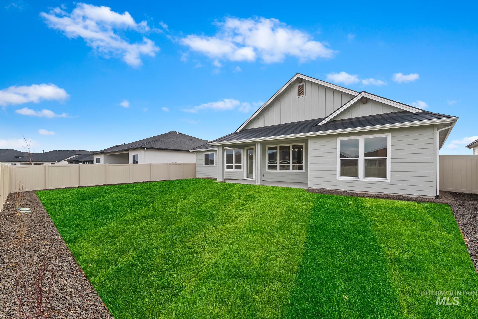 Back of property featuring board and batten siding, a fenced backyard, a patio, and roof with shingles