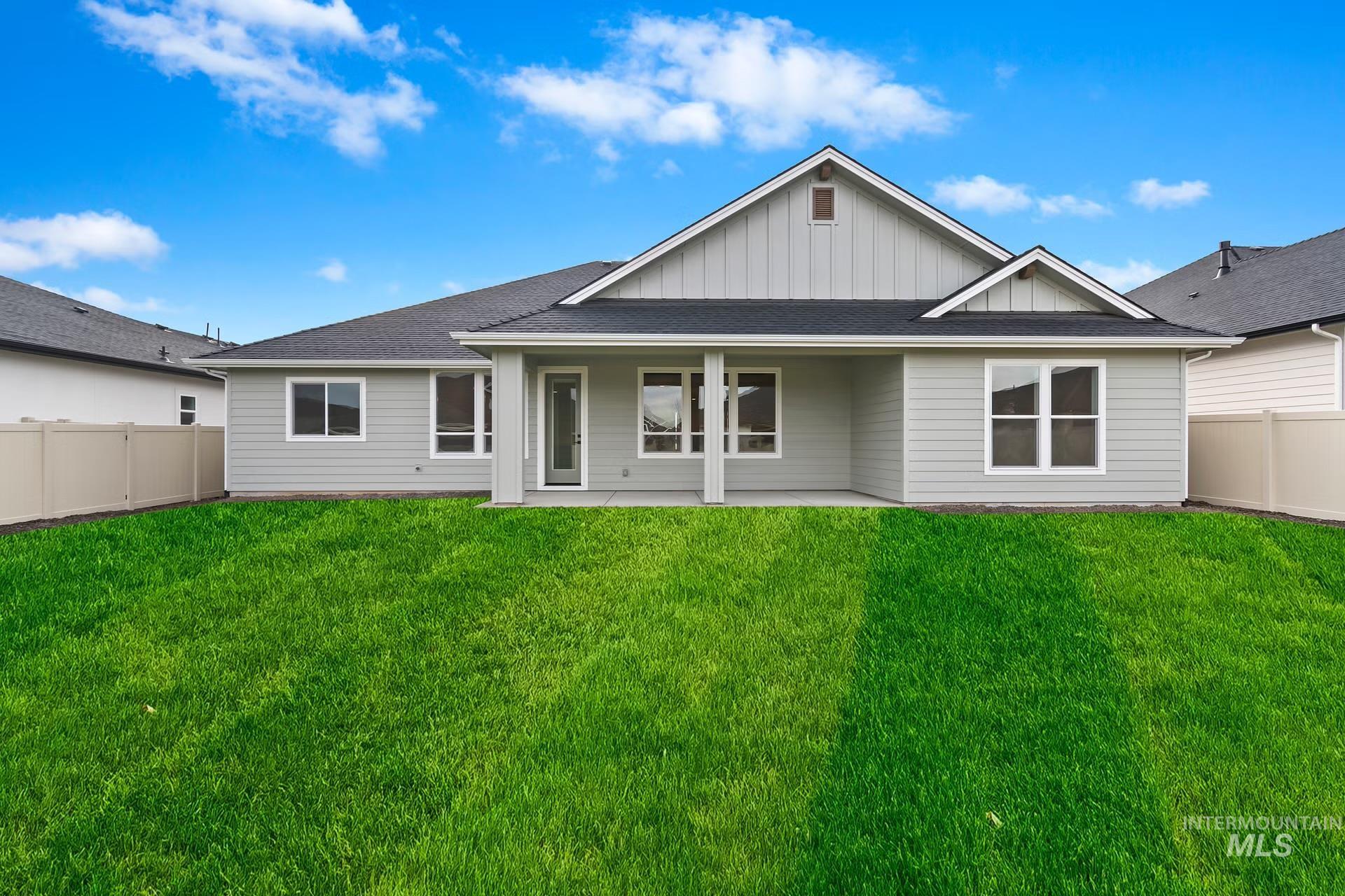 Rear view of house featuring a fenced backyard, board and batten siding, a patio area, and a shingled roof