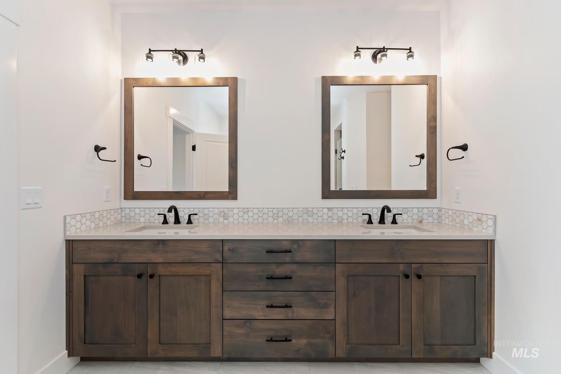 Full bath featuring double vanity and tasteful backsplash
