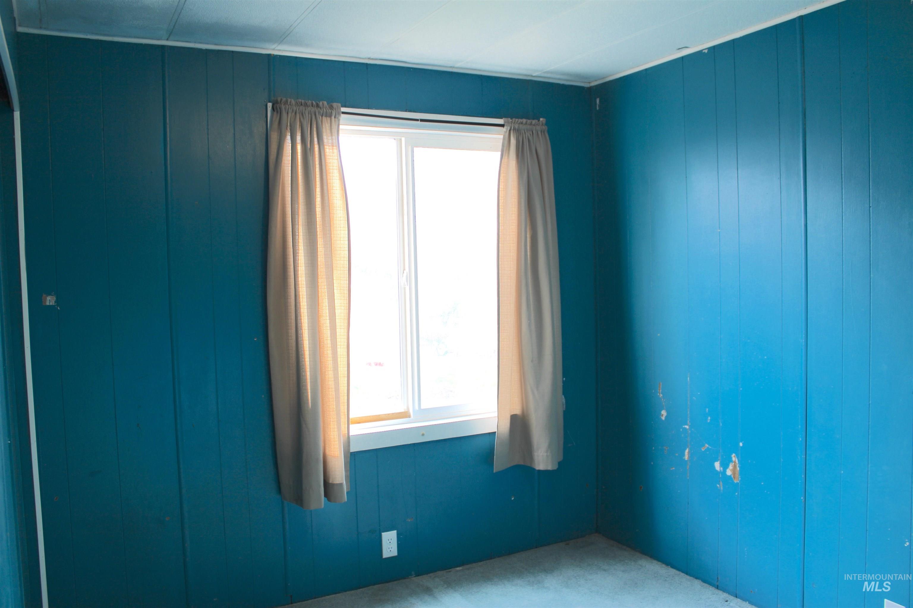 Spare room featuring wooden walls
