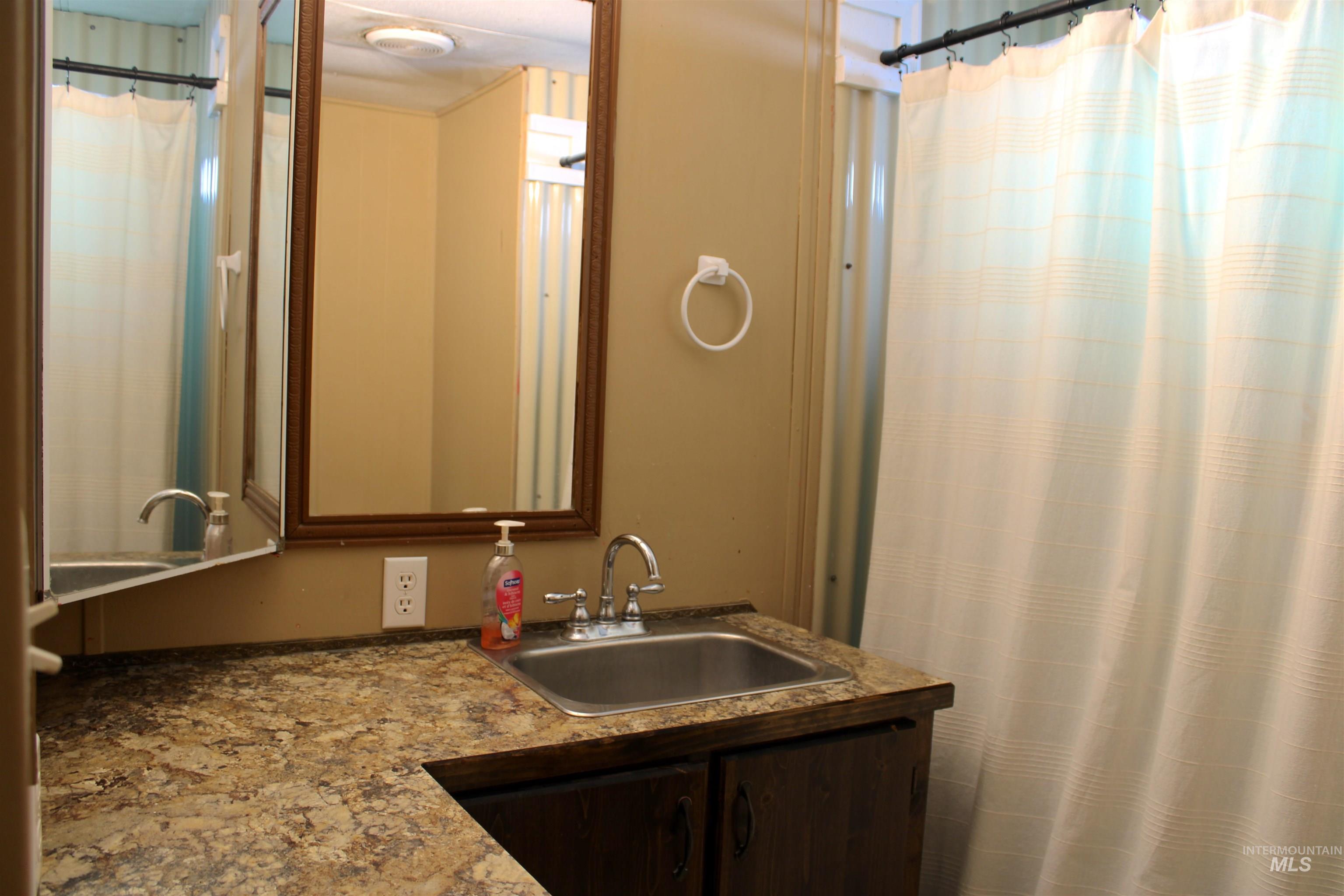 Full bath with vanity and a shower with shower curtain