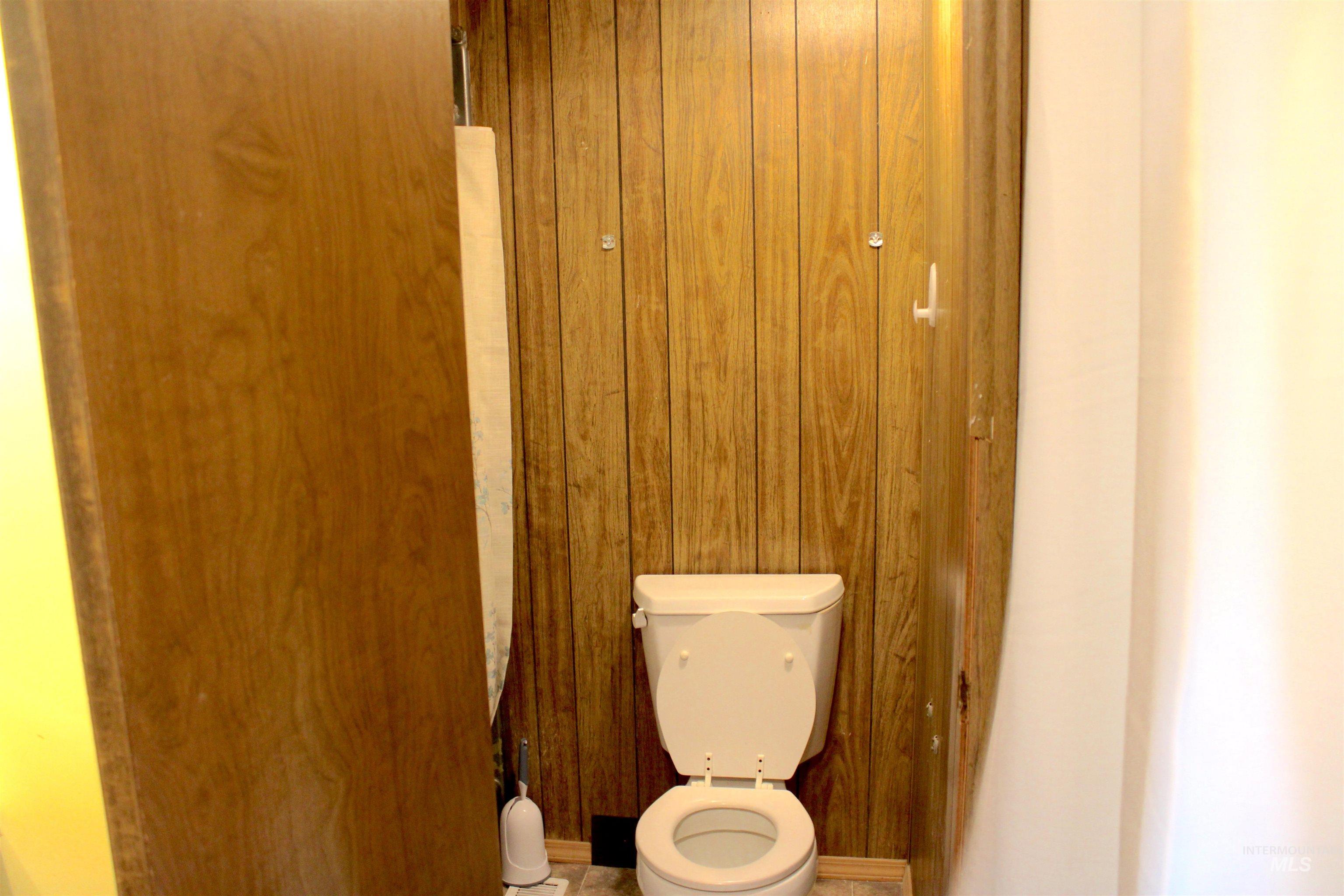 Bathroom with toilet and wooden walls