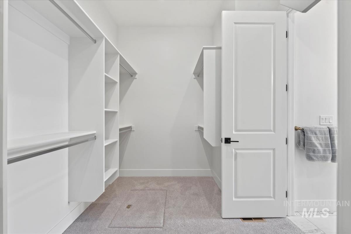 Spacious closet with light colored carpet