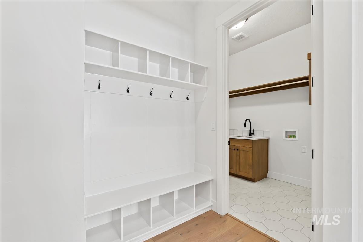 Mudroom featuring light wood finished floors and baseboards