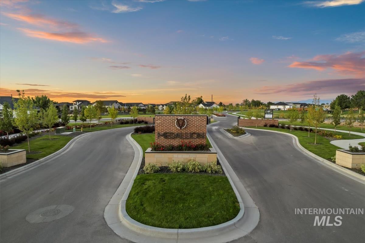 View of asphalt street featuring a residential view and curbs