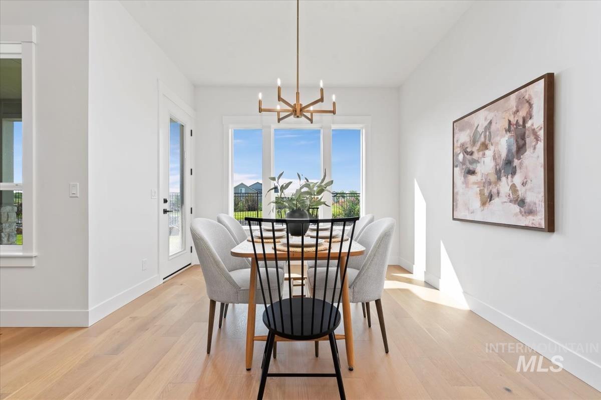 Dining room with light wood-style flooring and a chandelier