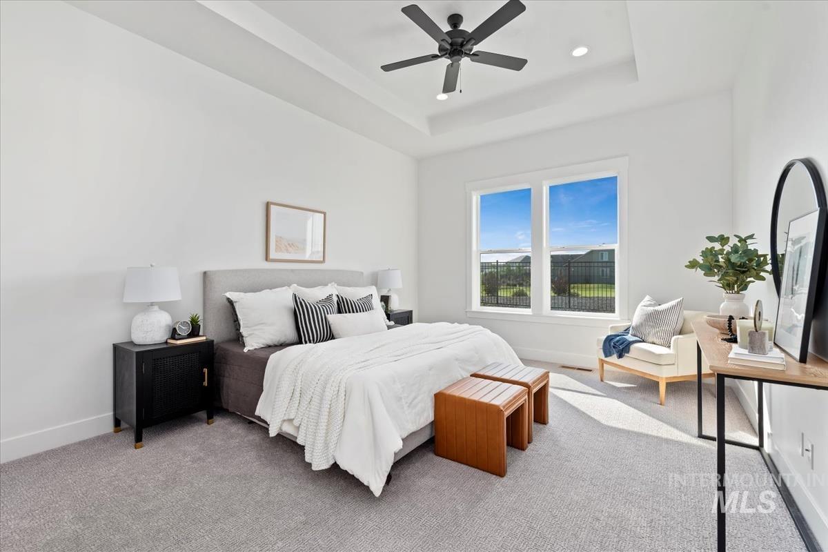 Bedroom featuring a ceiling fan, a tray ceiling, carpet floors, and recessed lighting