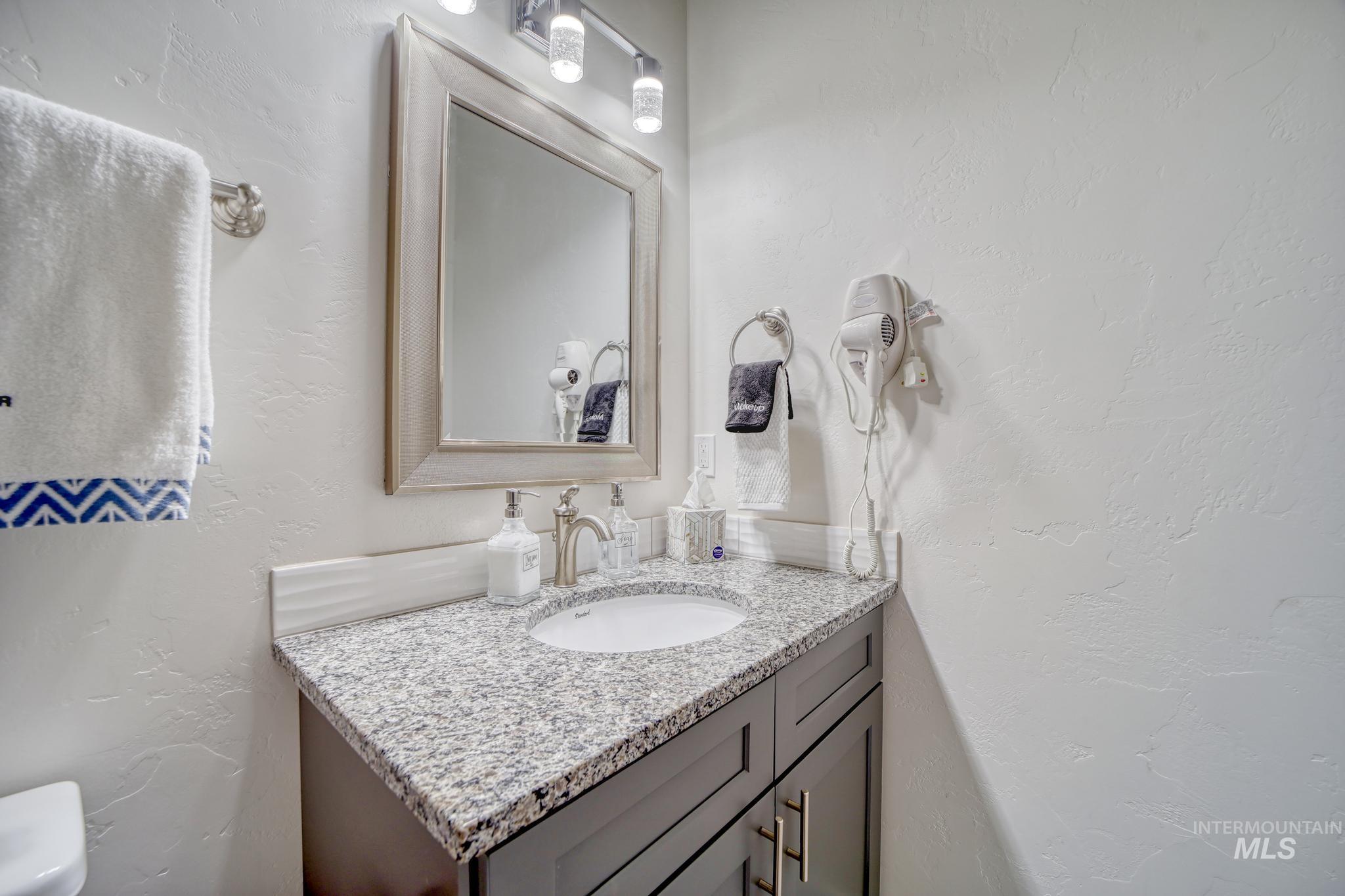 Half bathroom with a textured wall and vanity