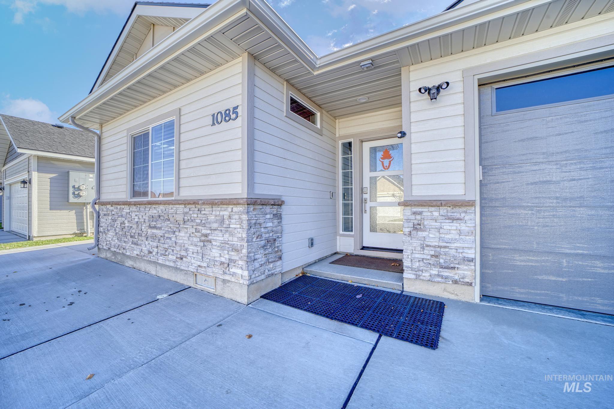 Entrance to property with stone siding and a garage