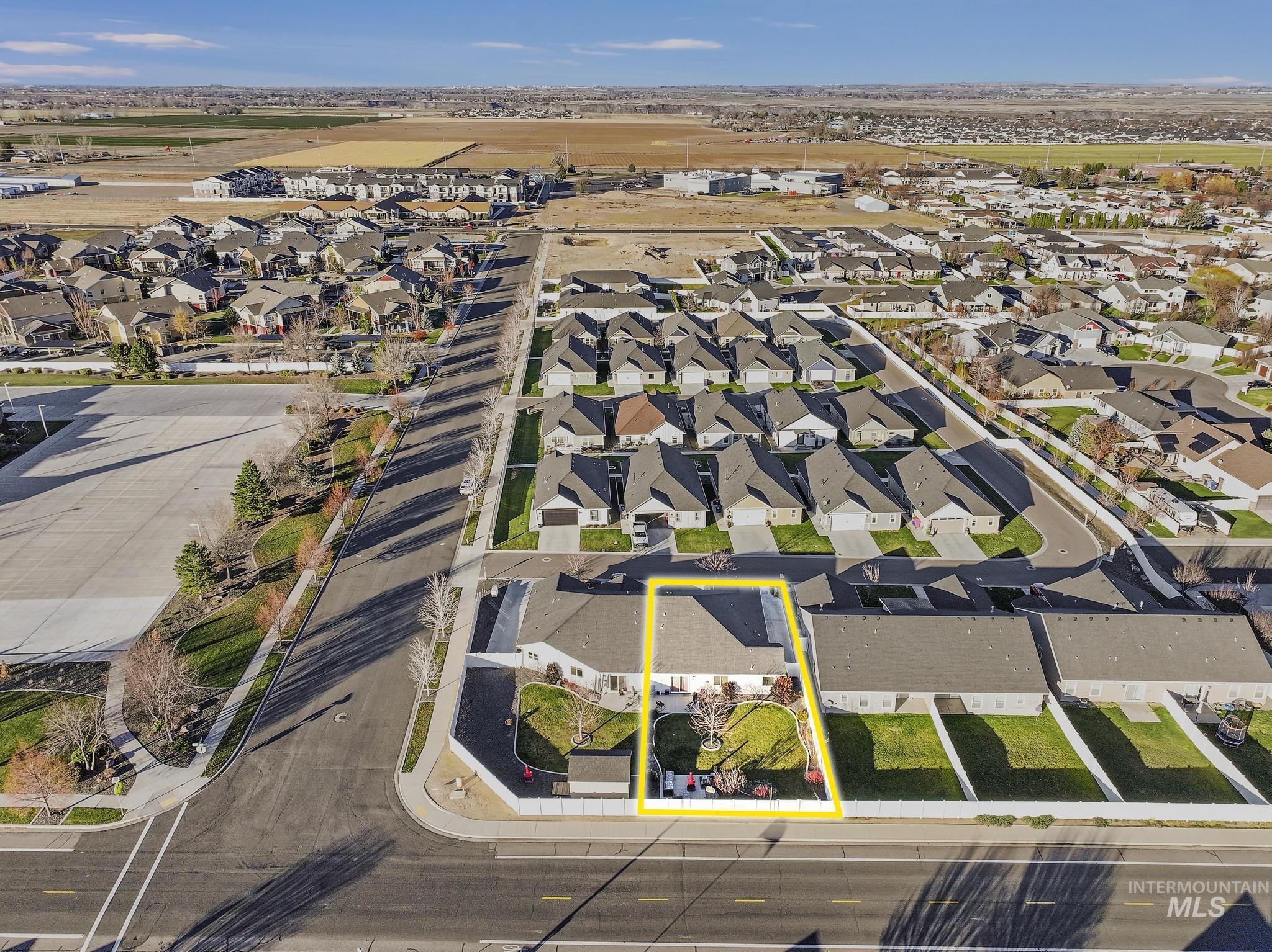 Aerial view of property and surrounding area featuring nearby suburban area and property parcel outlined