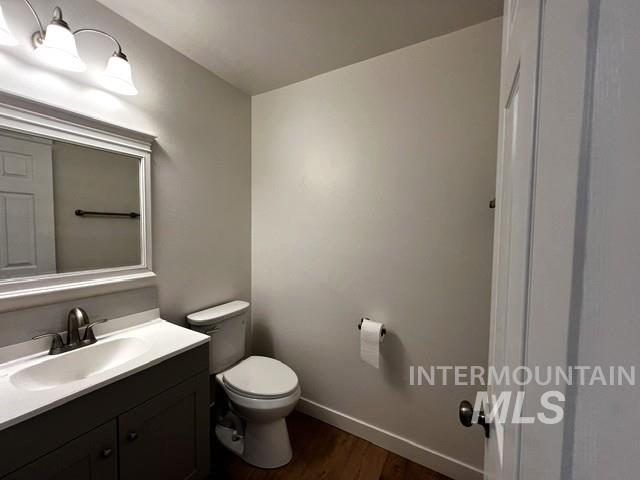Half bath featuring vanity and wood finished floors