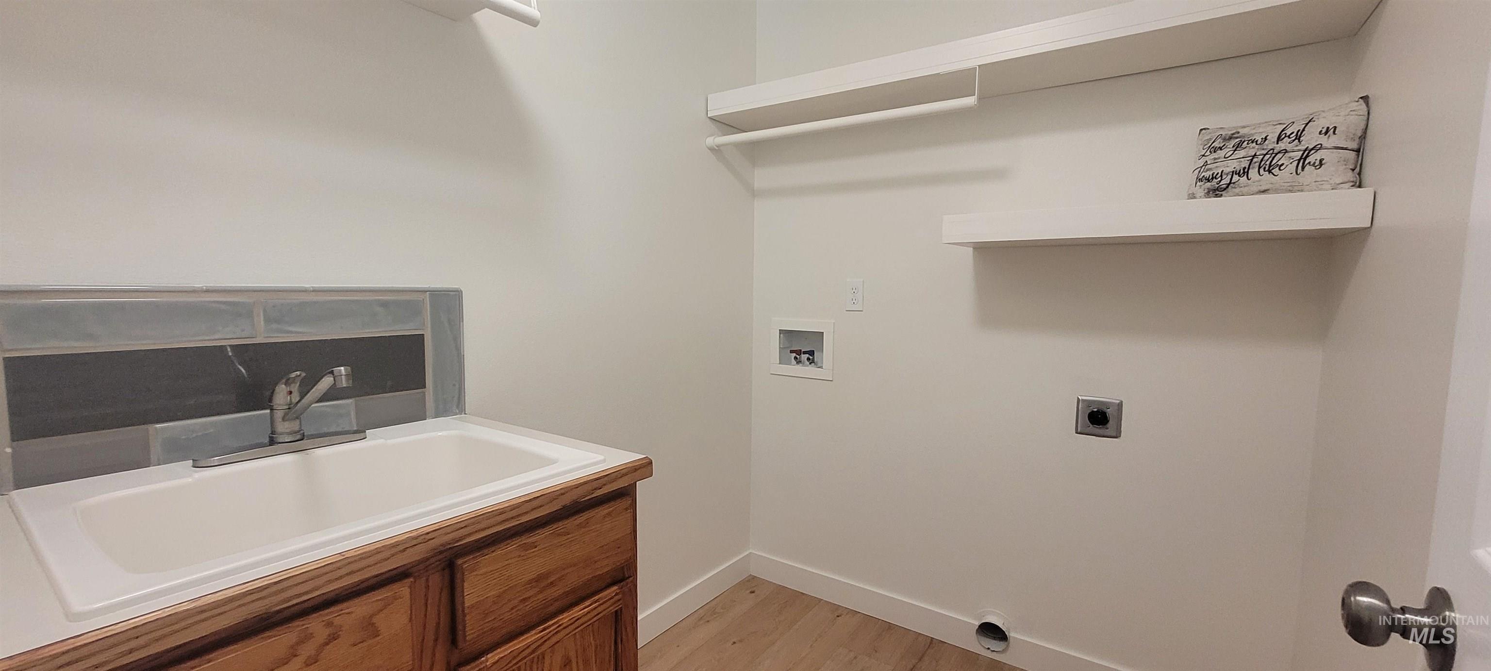 Washroom featuring hookup for a washing machine, electric dryer hookup, and light wood-type flooring