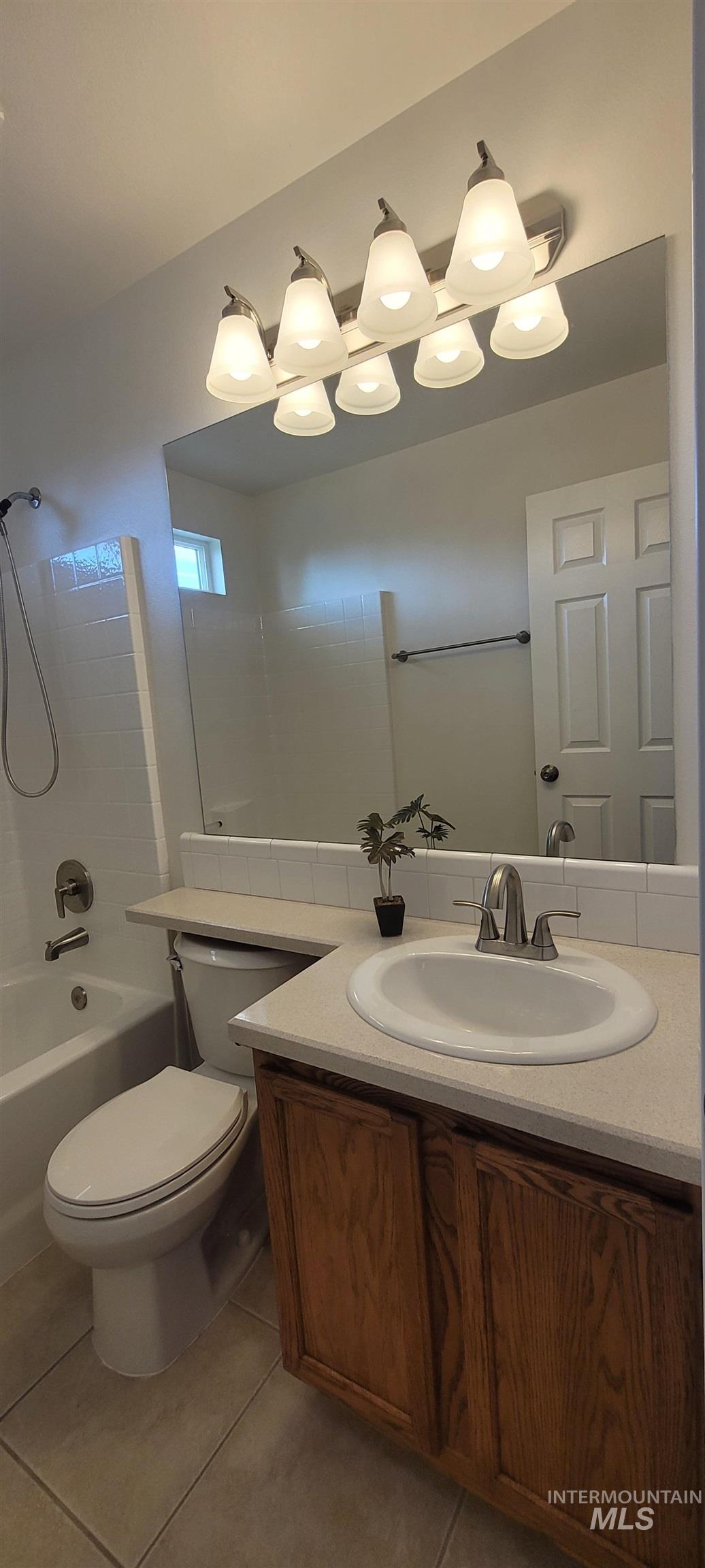 Bathroom with vanity, tile patterned flooring, and bathtub / shower combination