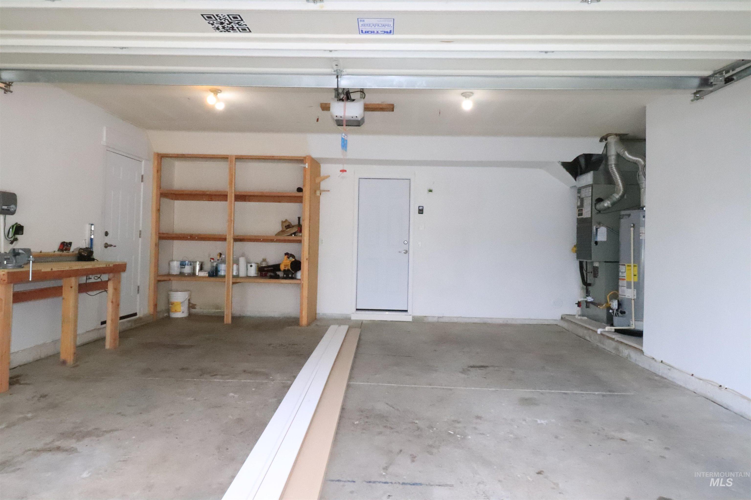 Garage featuring gas water heater and a garage door opener