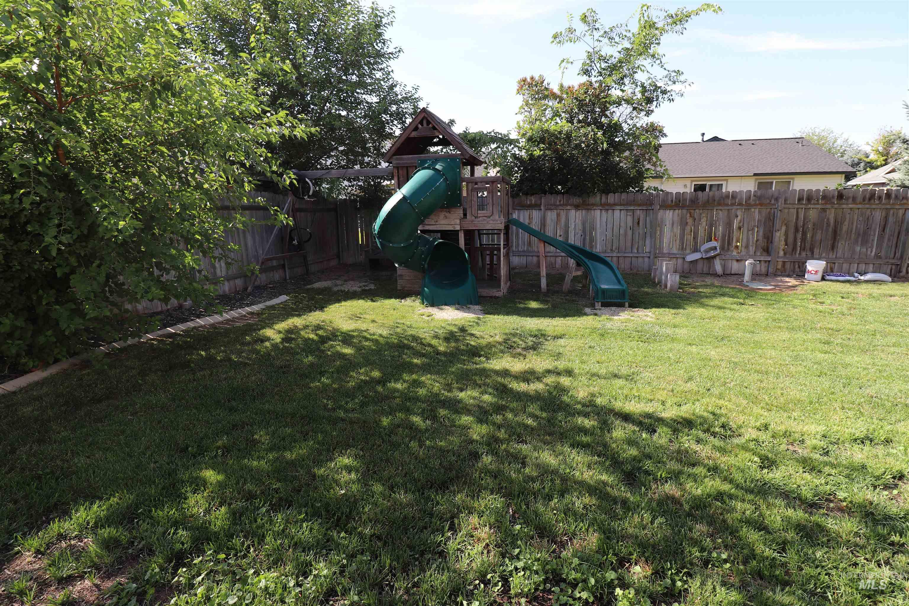 Fenced backyard with a playground