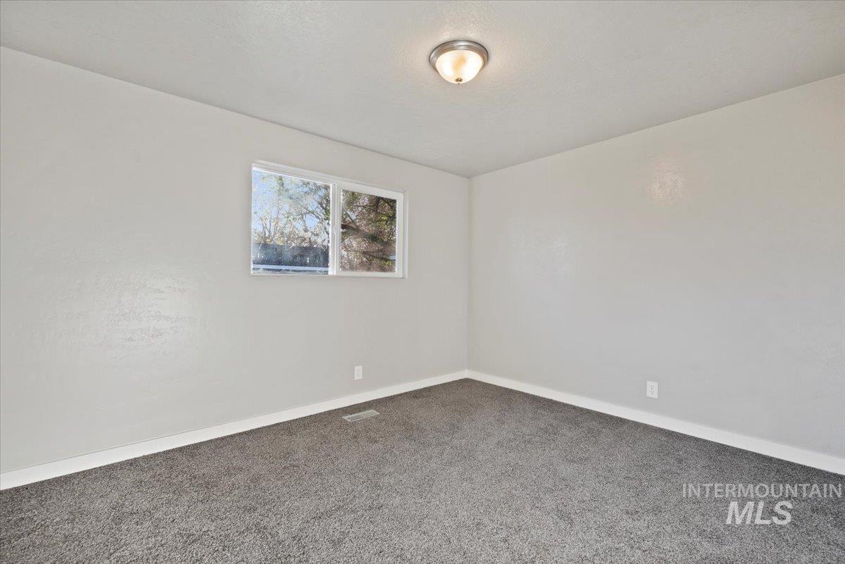 Carpeted spare room with baseboards