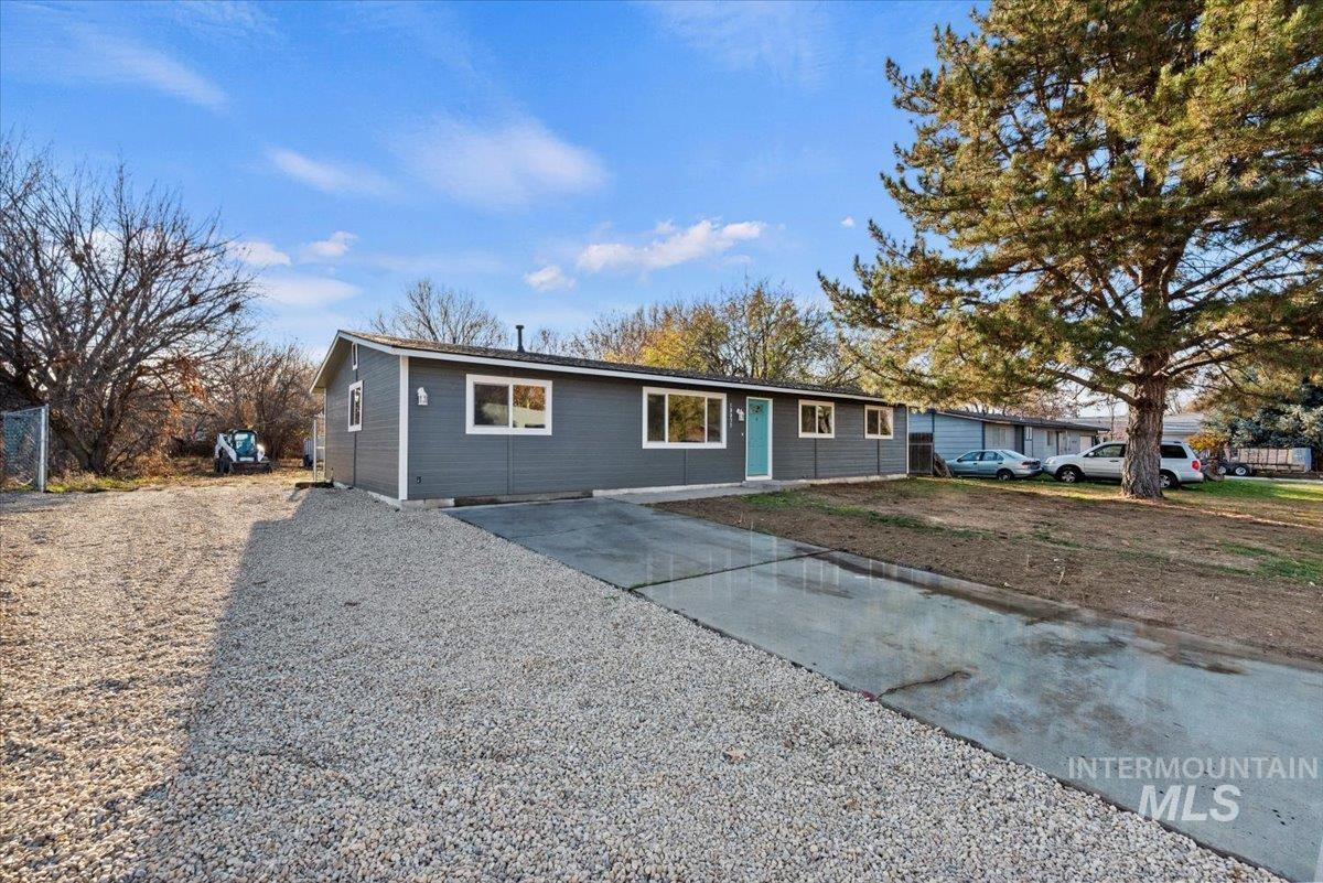 Single story home featuring gravel driveway