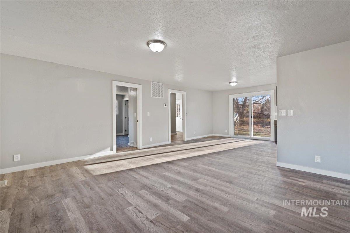 Spare room with a textured ceiling and wood finished floors
