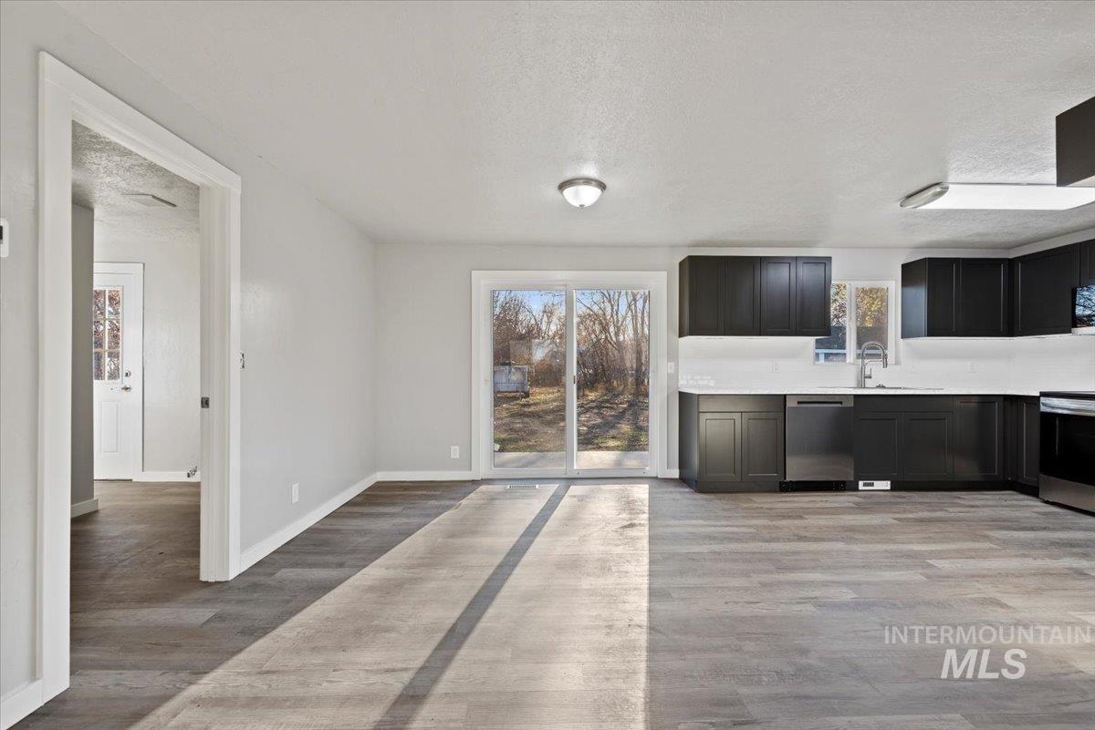 Unfurnished dining area featuring a textured ceiling and light wood-style flooring