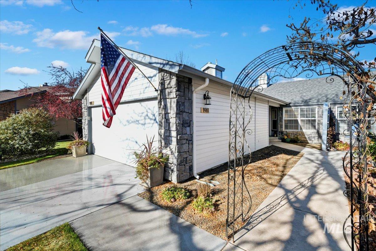 View of side of property with driveway and stone siding