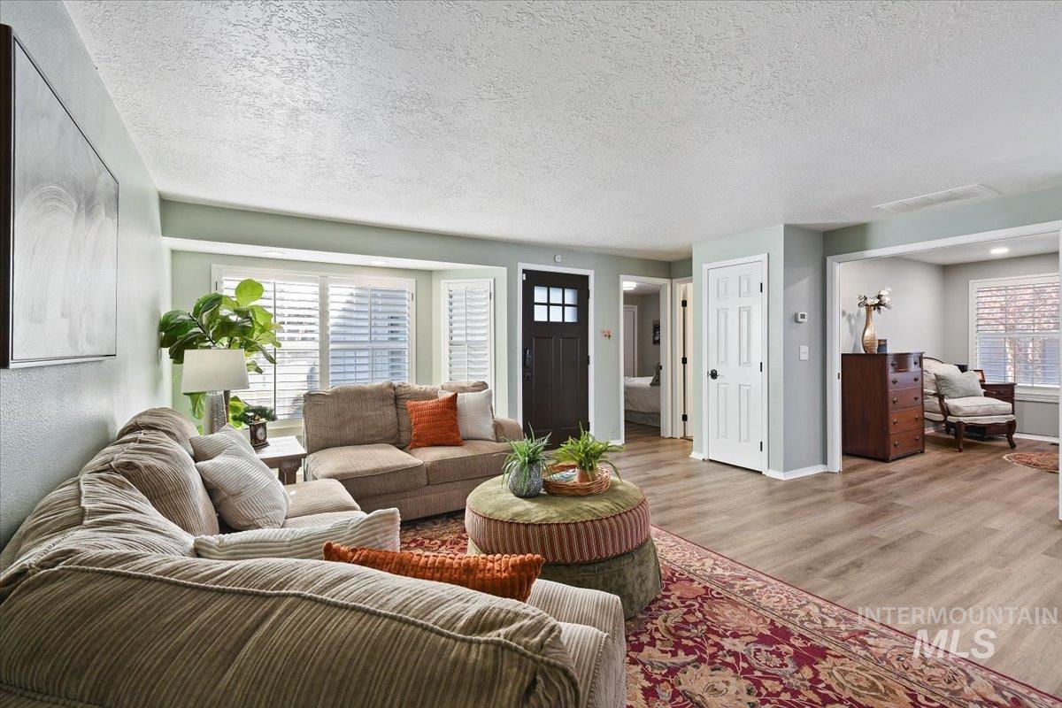 Living room featuring a textured ceiling, plenty of natural light, and wood finished floors