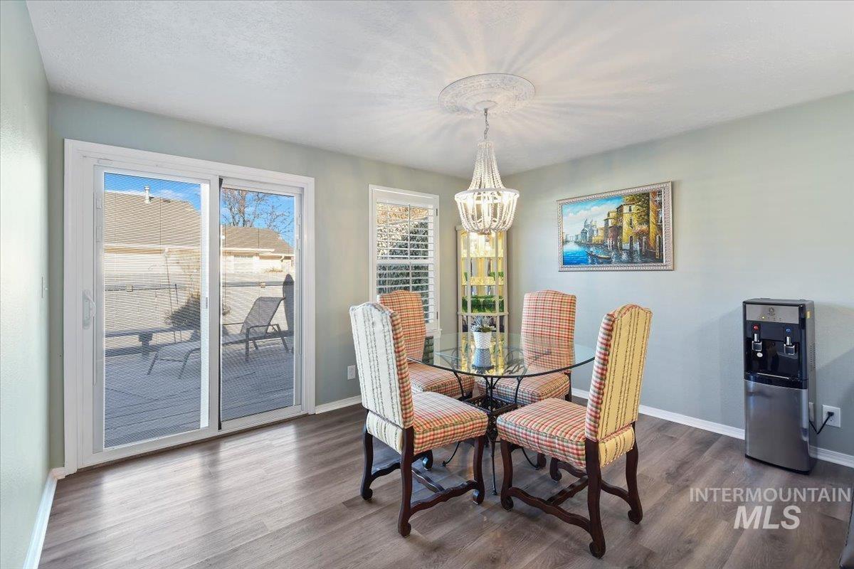 Dining room featuring dark wood-style flooring and a chandelier