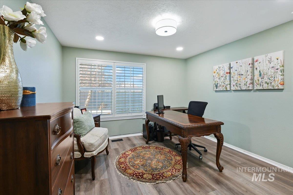 Home office with a textured ceiling, wood finished floors, and recessed lighting