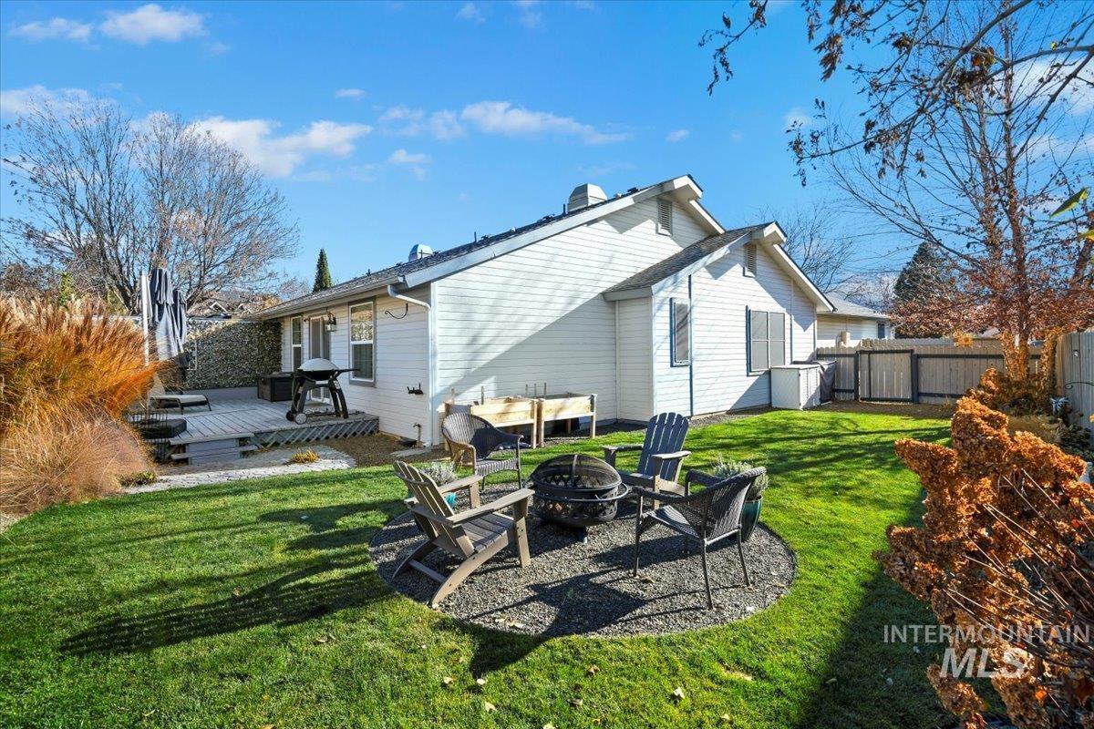 Rear view of house featuring a wooden deck and an outdoor fire pit