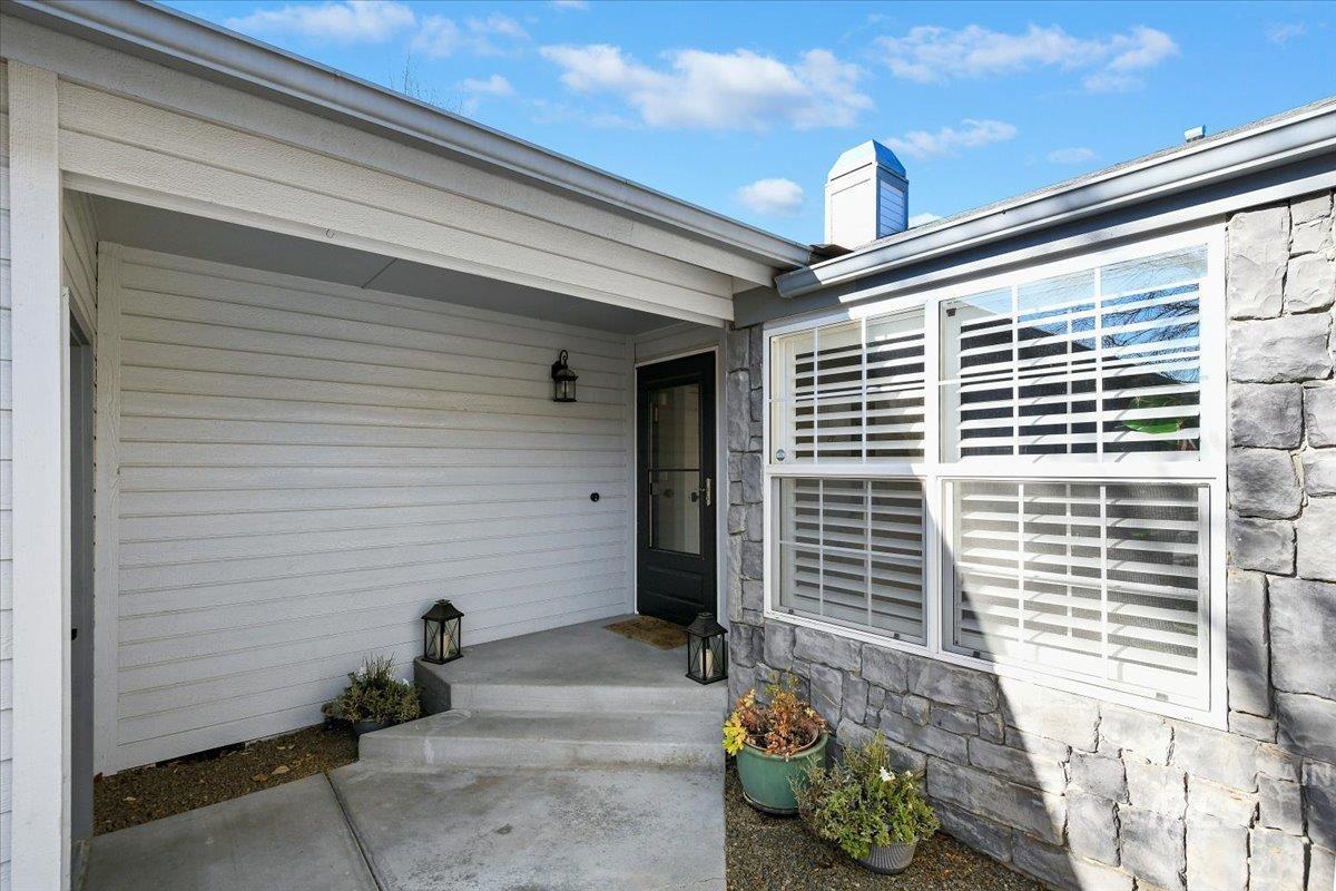 Entrance to property with stone siding and a chimney