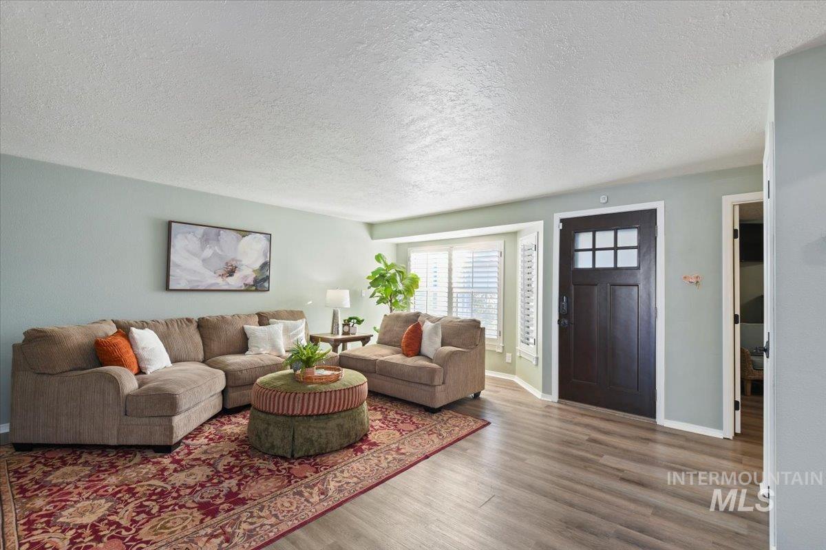 Living room featuring a textured ceiling and wood finished floors