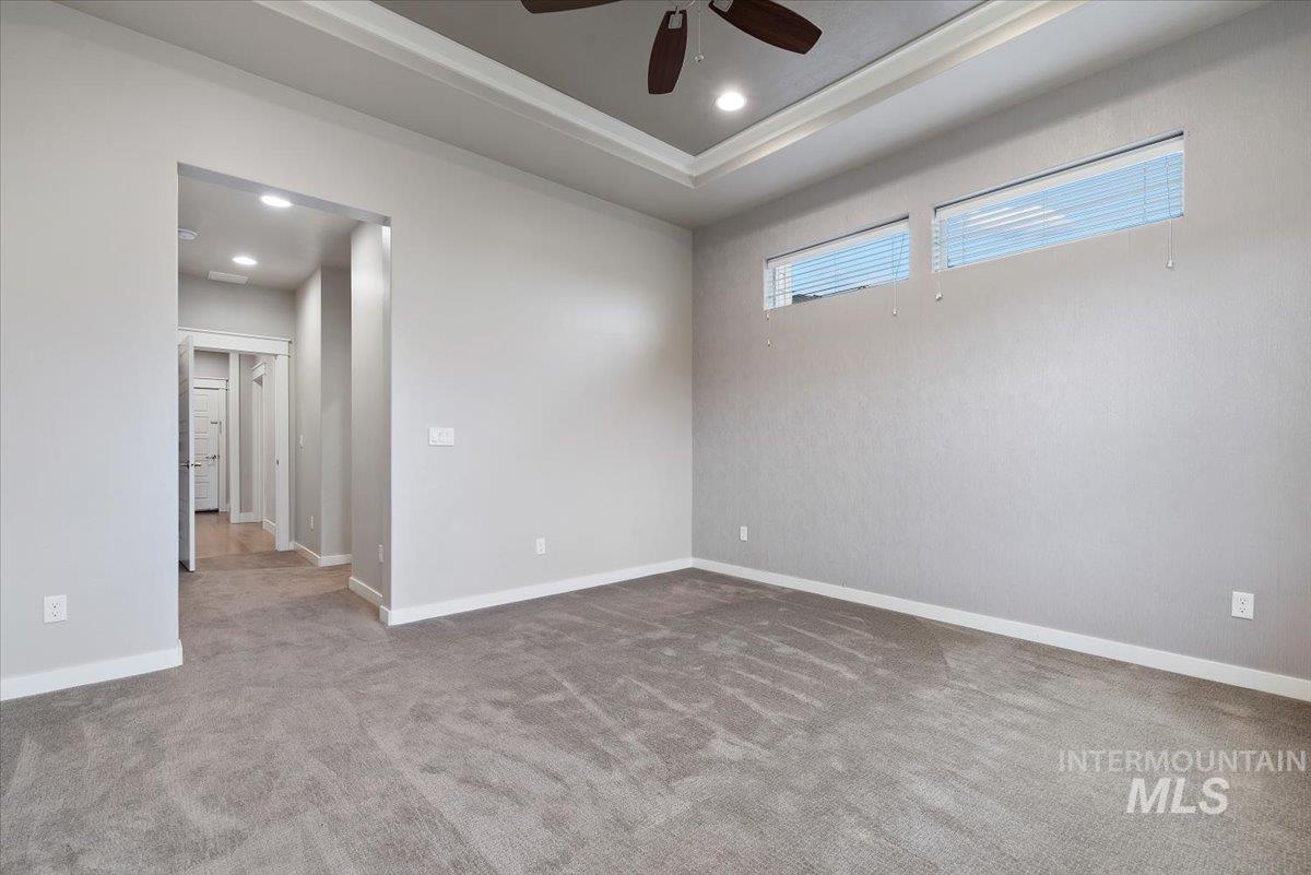 Spare room with ceiling fan, carpet flooring, recessed lighting, and a tray ceiling