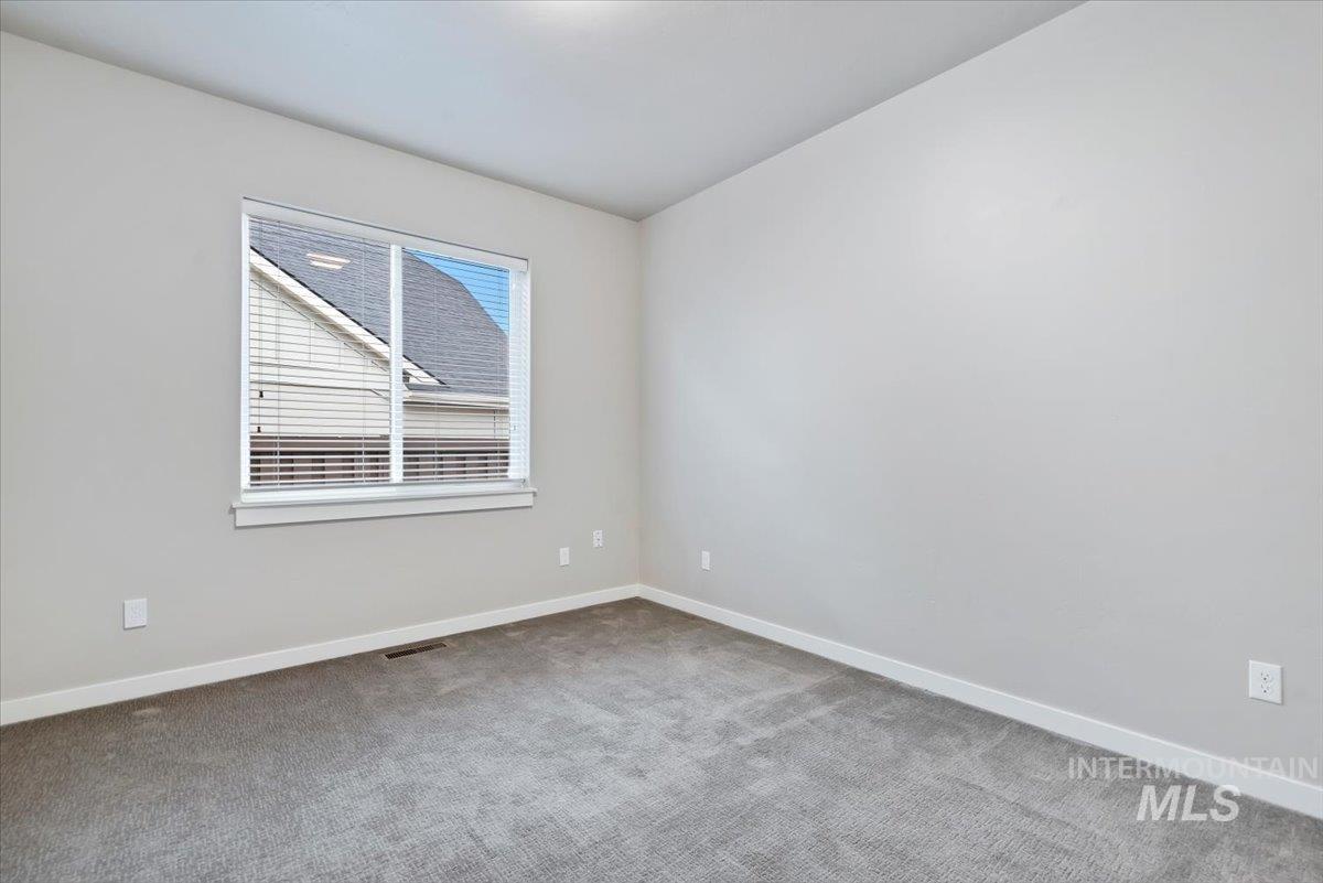 Empty room featuring baseboards and carpet flooring
