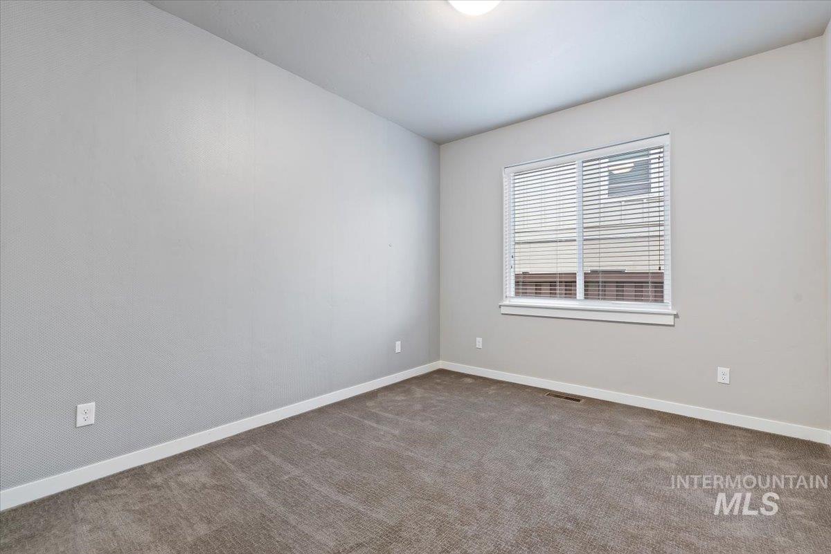 Carpeted empty room featuring baseboards