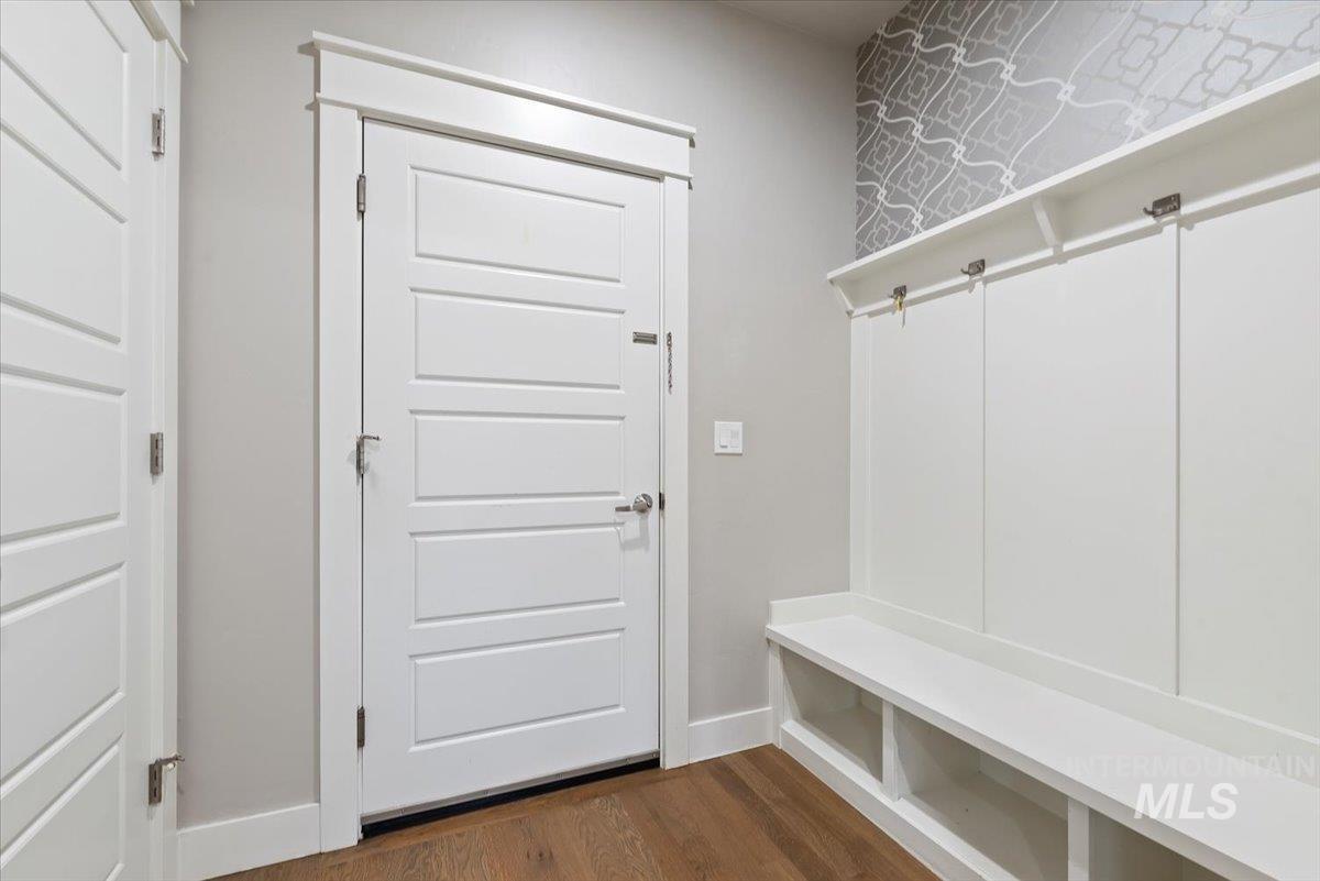 Mudroom with dark wood-type flooring and baseboards
