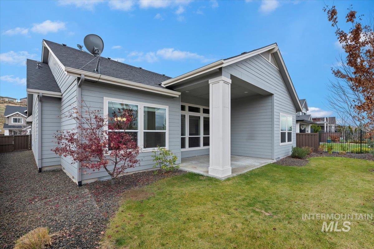 Back of house featuring a patio and roof with shingles
