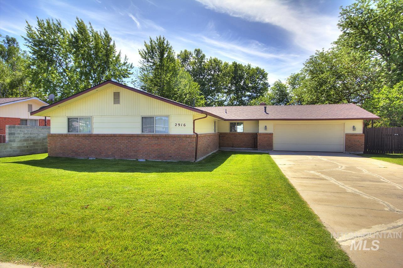 Single story home featuring brick siding, concrete driveway, and an attached garage