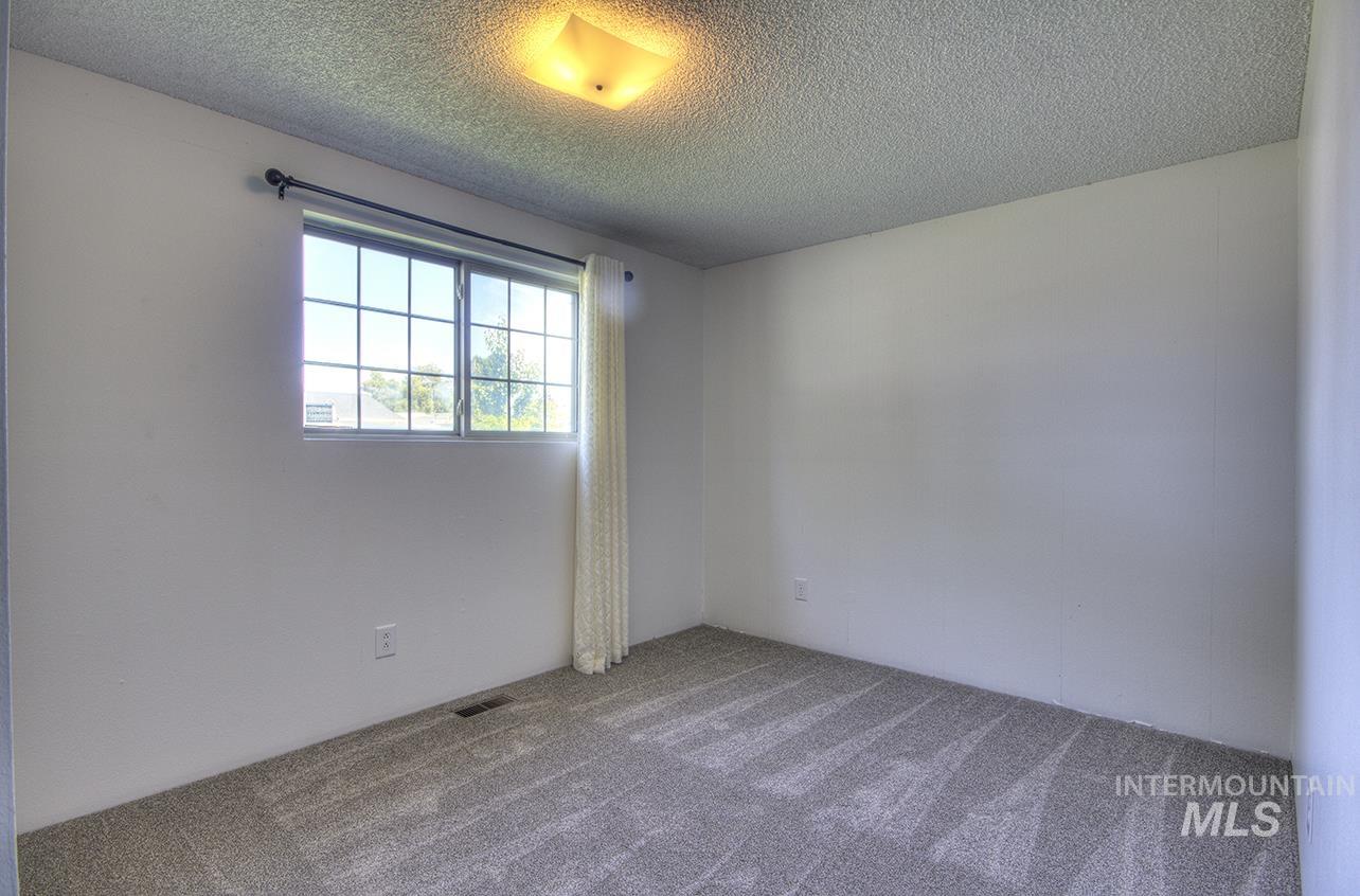Spare room with a textured ceiling and carpet