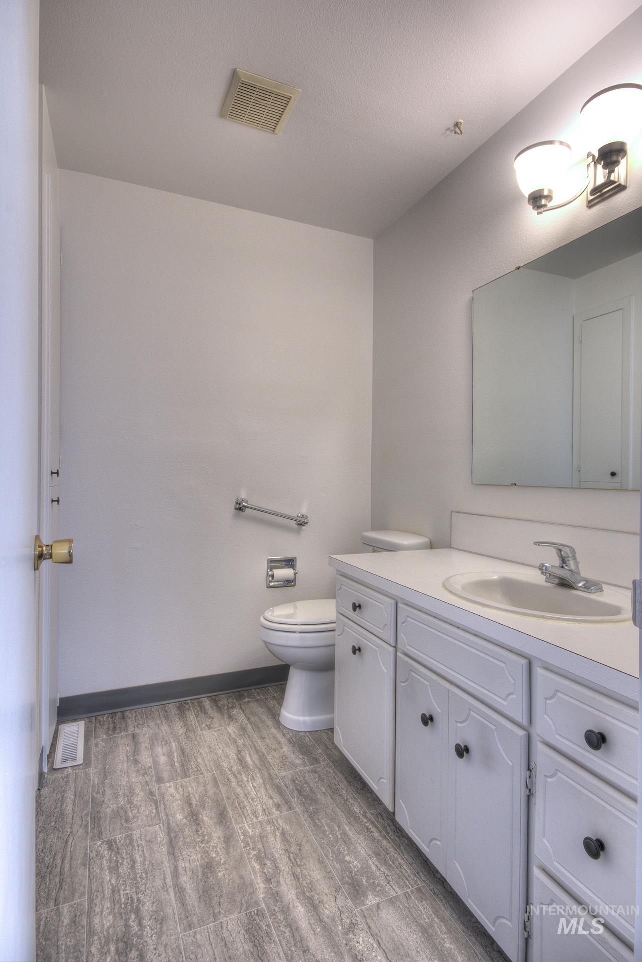 Half bathroom with vanity and light wood-style flooring