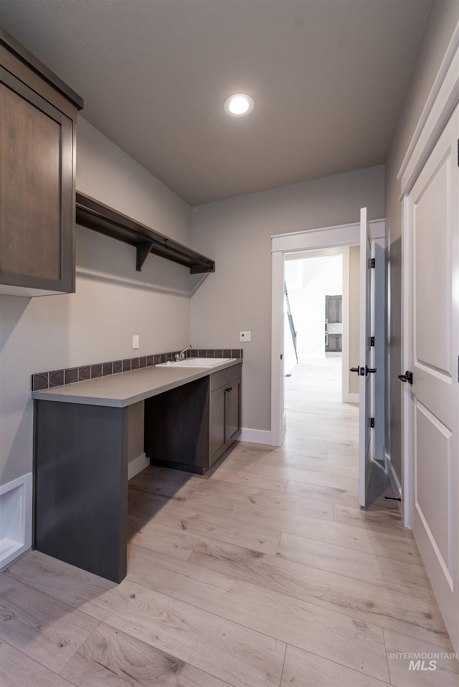 Washroom with light wood finished floors, recessed lighting, and cabinet space