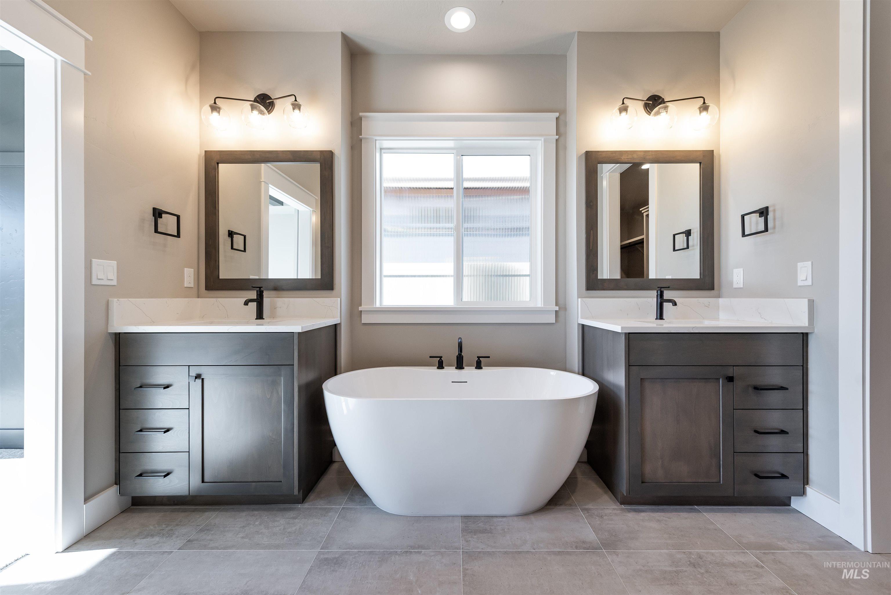 Bathroom featuring a soaking tub and two vanities