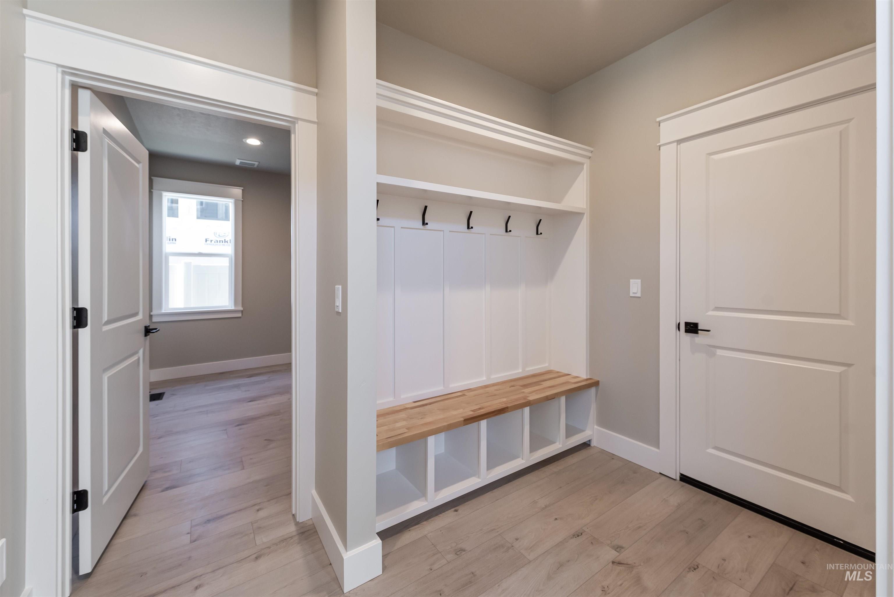 Mudroom featuring light wood finished floors and baseboards