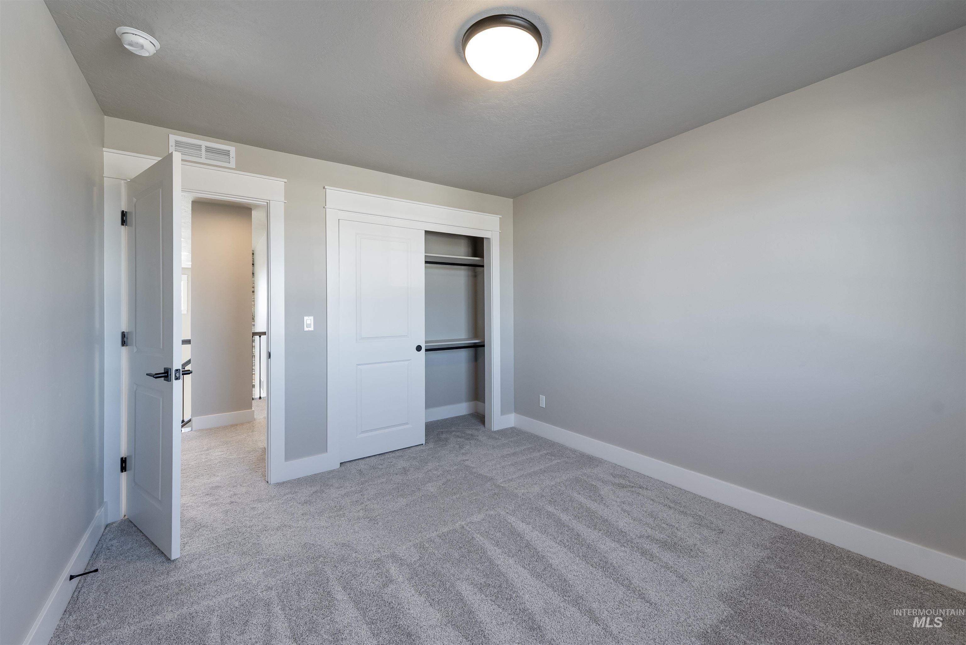 Unfurnished bedroom with a closet and light carpet