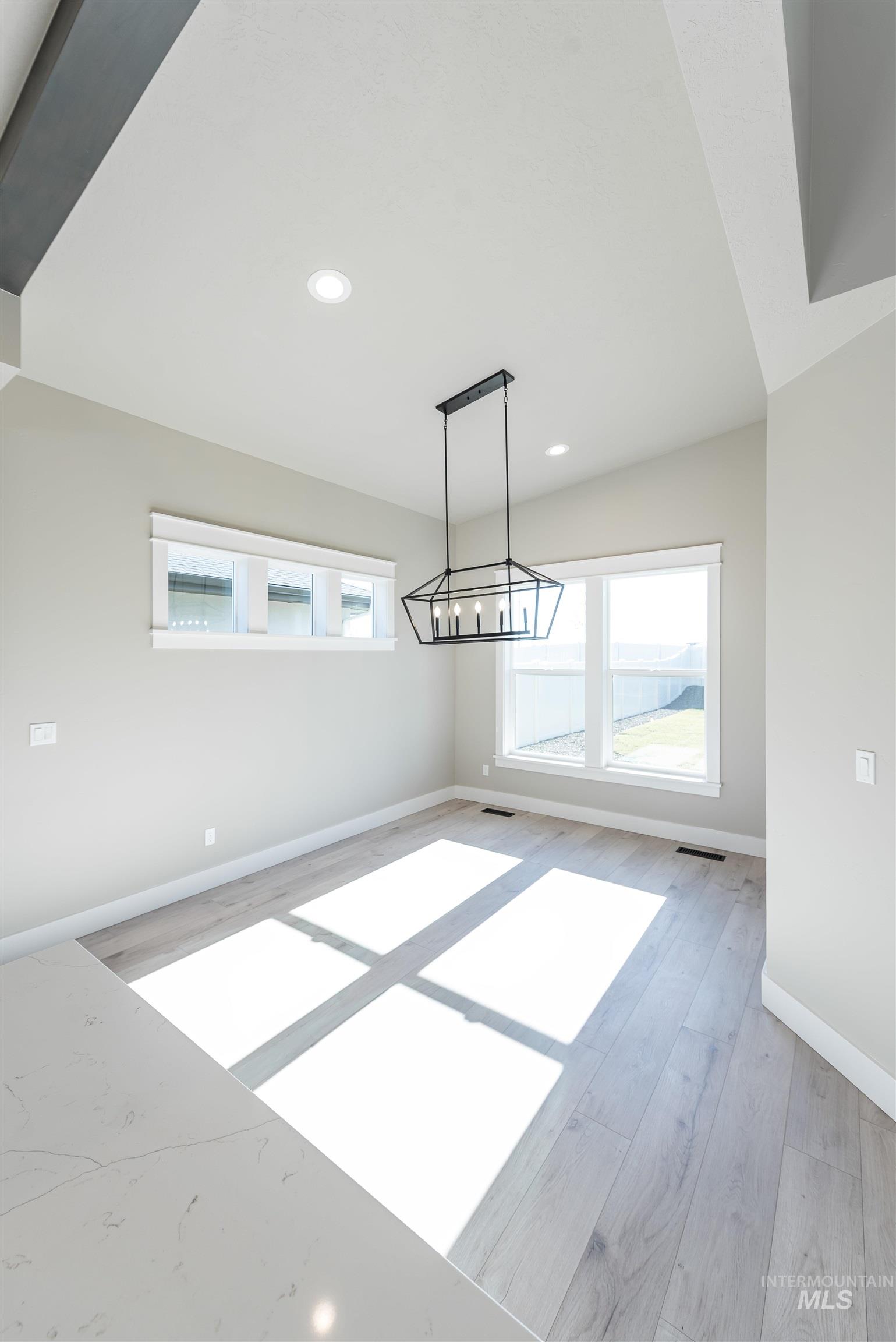 Unfurnished dining area with recessed lighting, plenty of natural light, light wood-style floors, and a chandelier