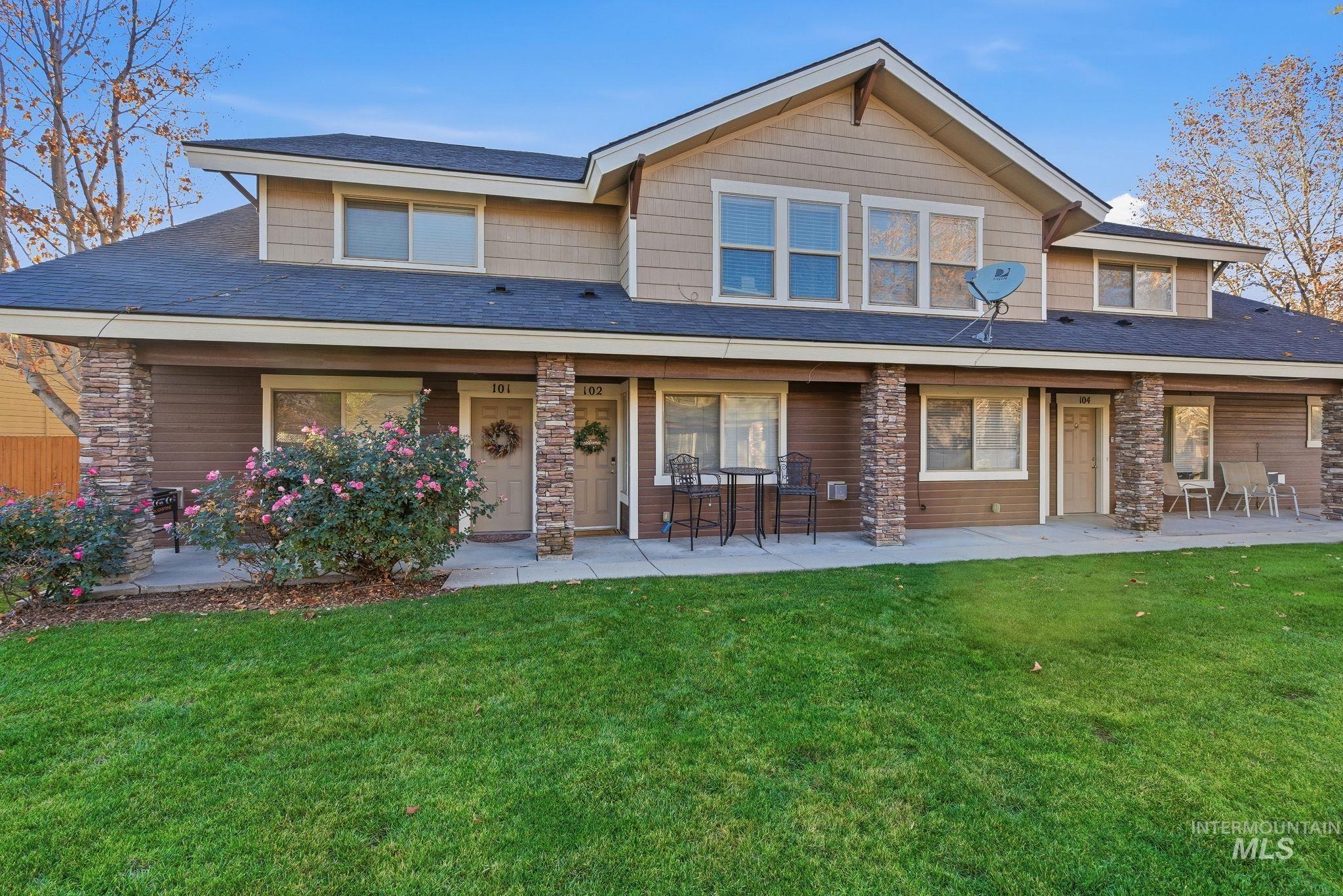 View of front of home featuring a front lawn, roof with shingles, and a patio
