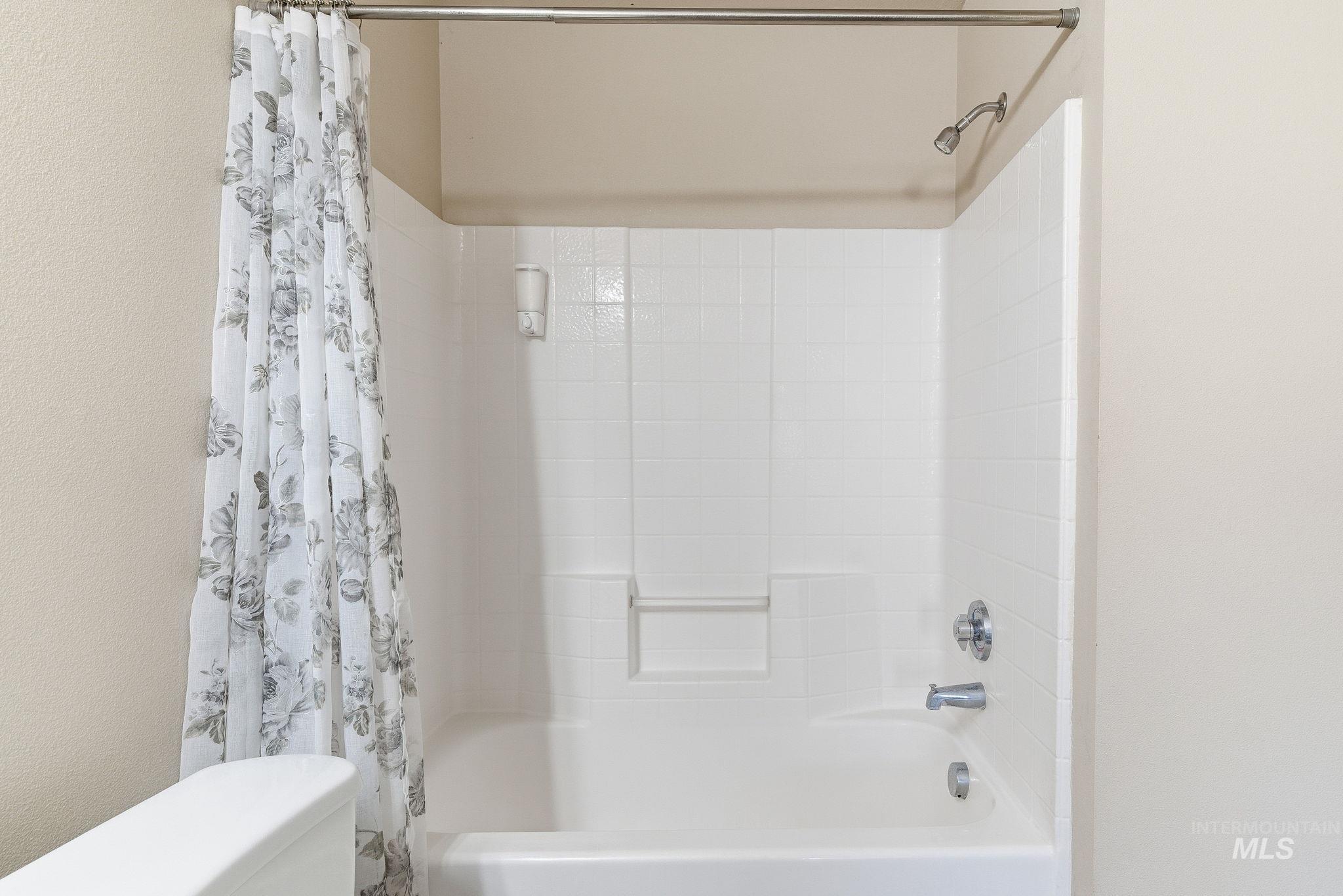 Full bathroom featuring shower / tub combo and toilet
