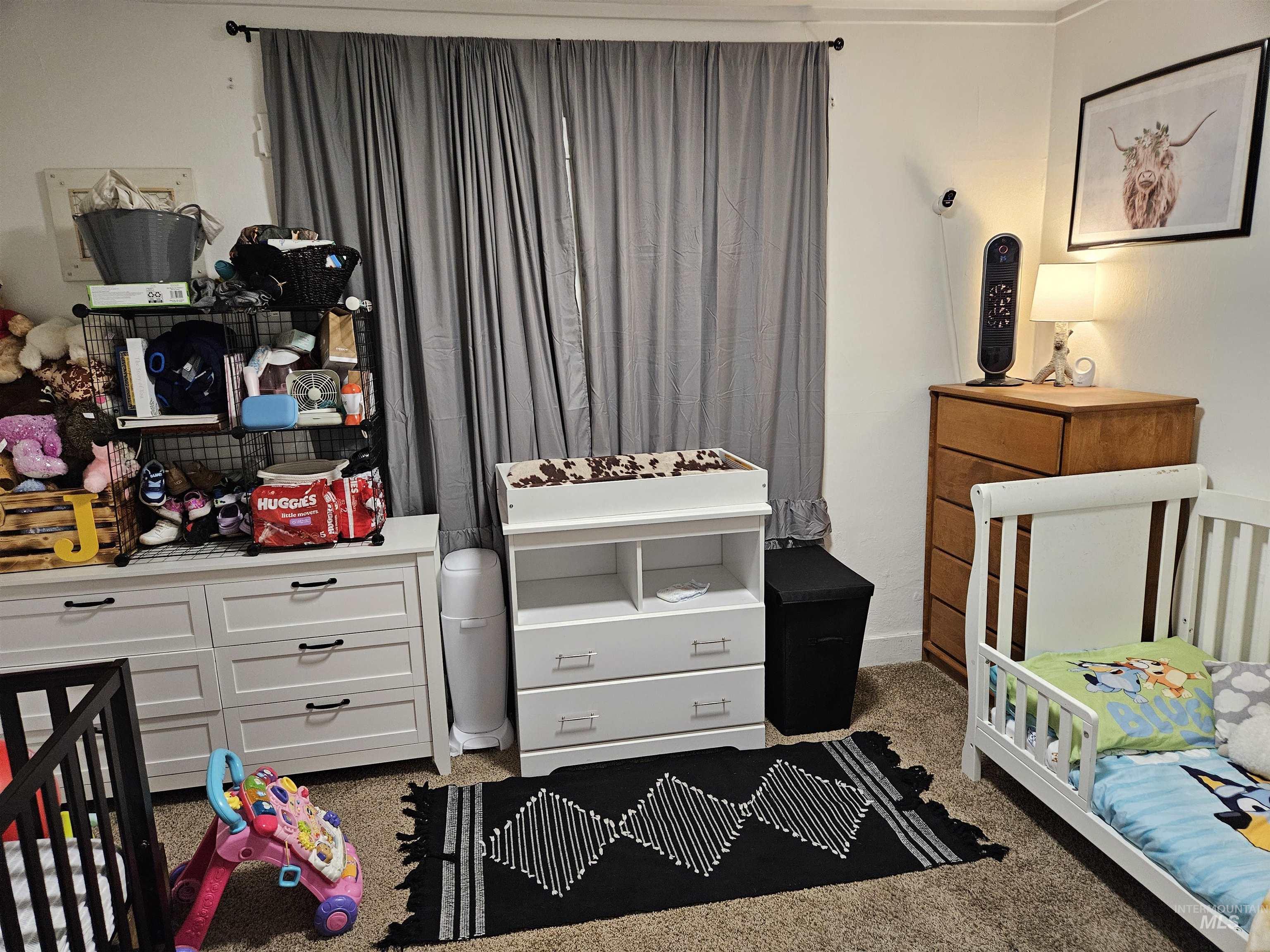 Bedroom featuring a crib and carpet floors