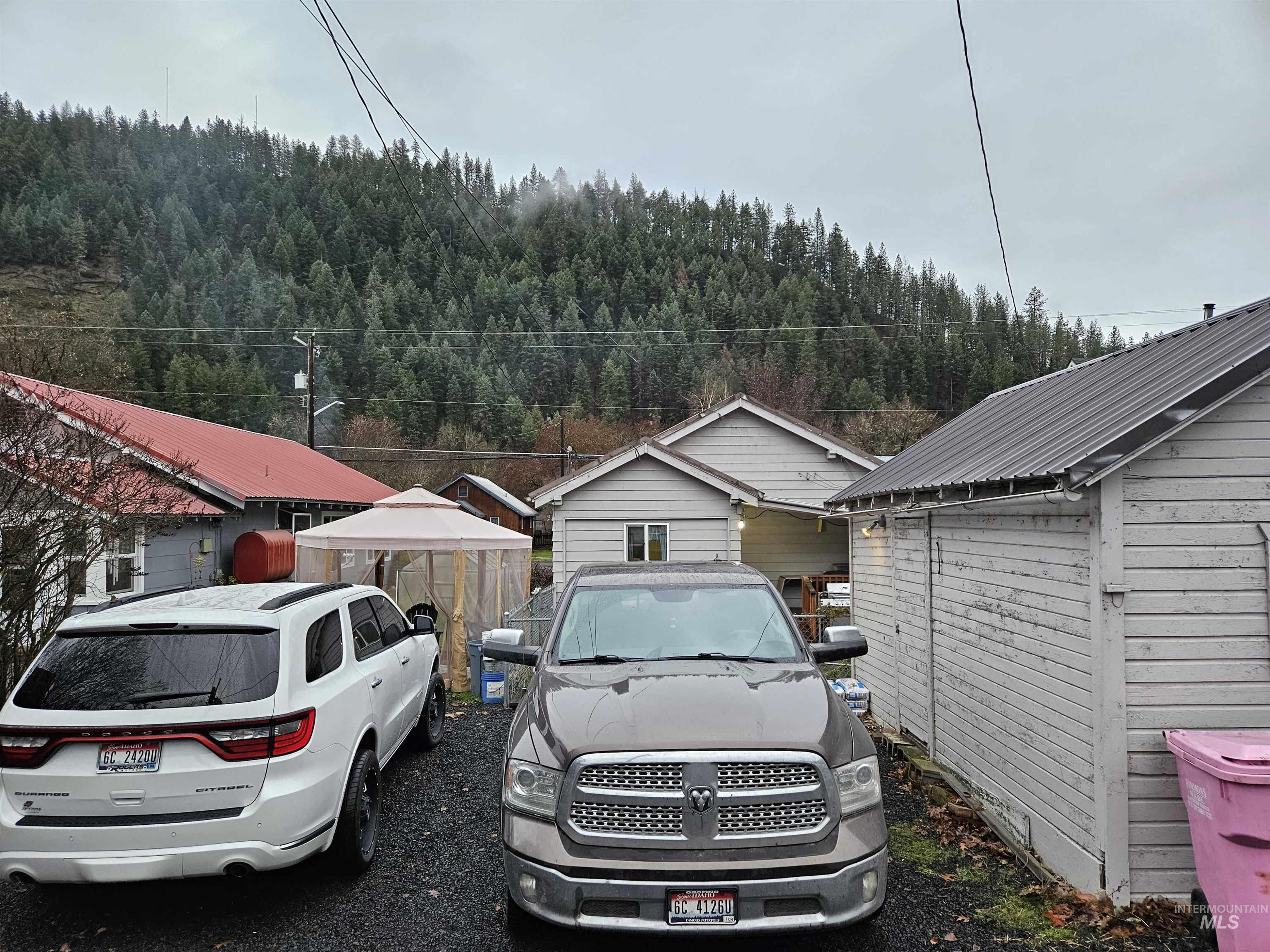 View of parking / parking lot featuring oil tank and a wooded view