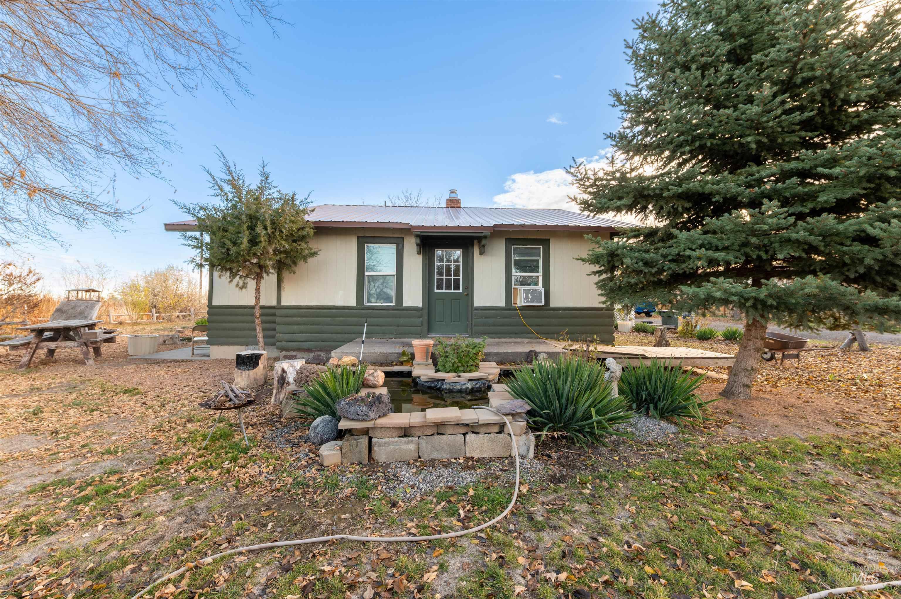 Rear view of property featuring a metal roof, a chimney, and a patio